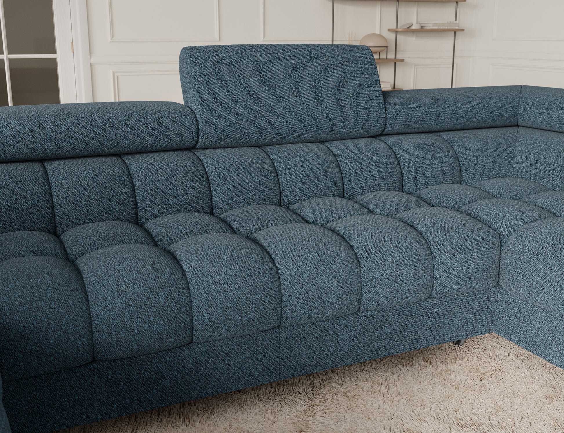 Zbliżenie na narożnik Fectory w niebieskim odcieniu, z wyraźnie widocznymi subtelnymi detali tapicerki i metalowymi nogami.