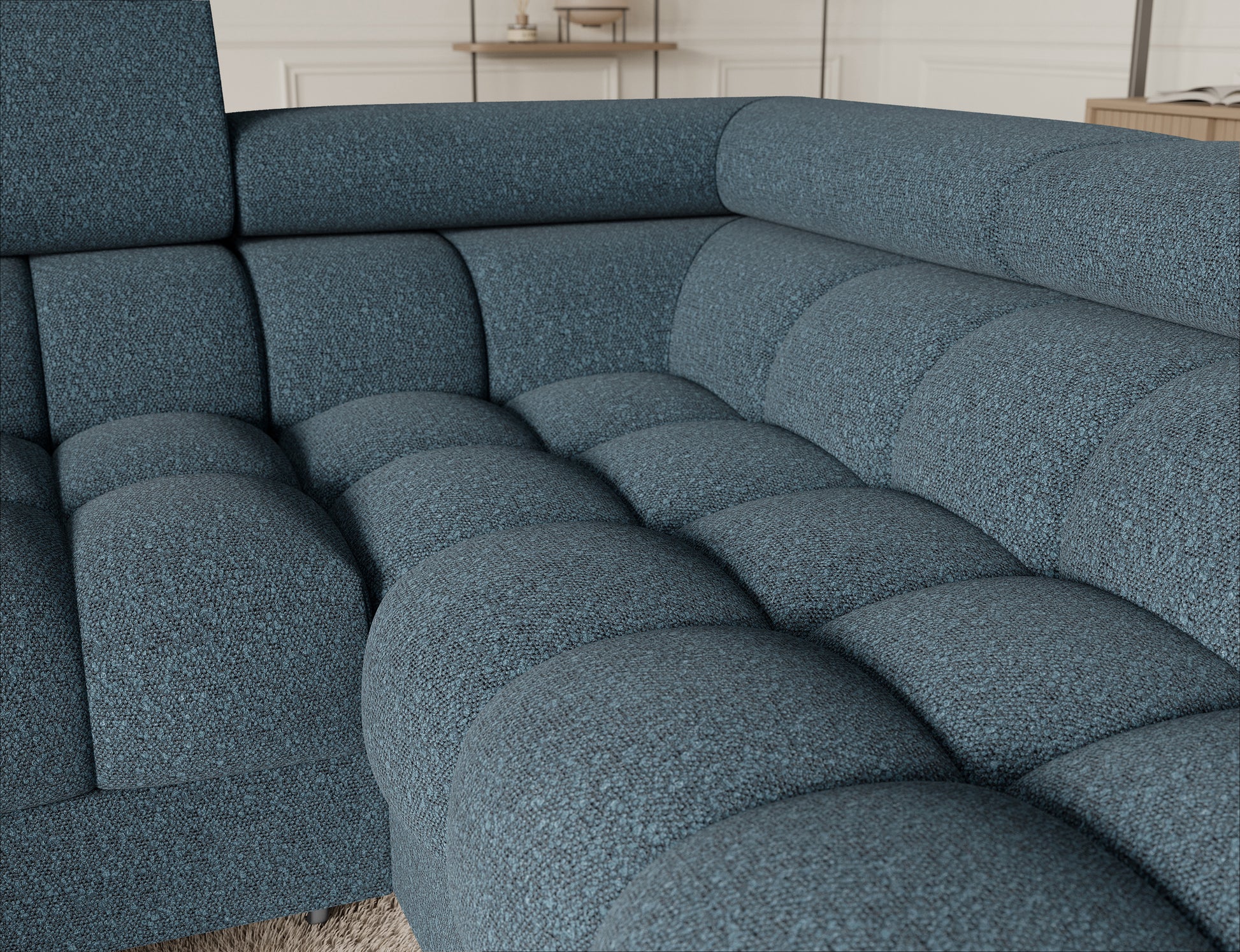 Detal narożnika Fectory w niebieskim kolorze, ukazujący teksturę materiału tapicerki oraz elegancki design z metalowymi nogami.