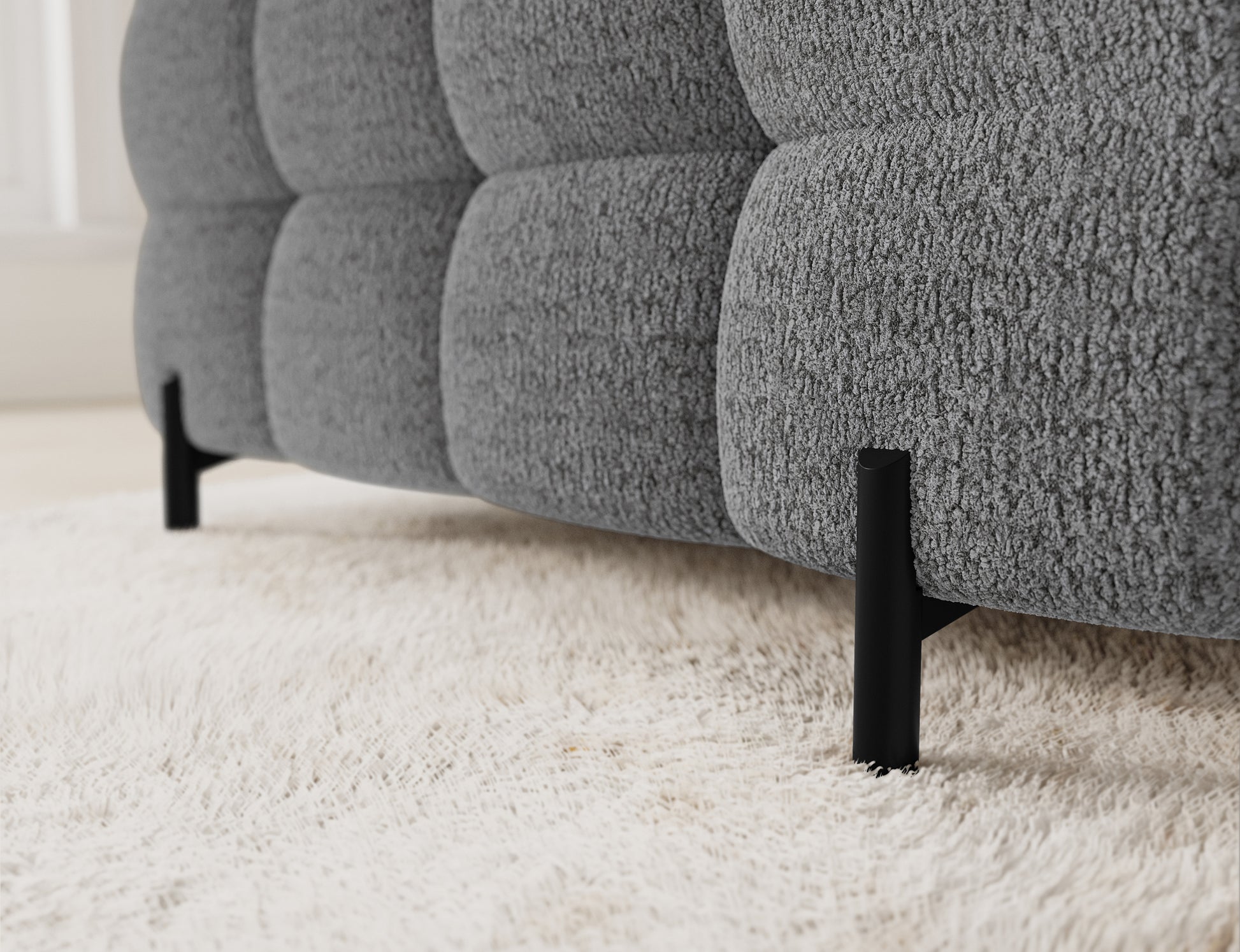 Zbliżenie na metalowe nóżki narożnika Fectory w jasnoszarej tkaninie Royal 03, widoczny kształt obicia i detale.