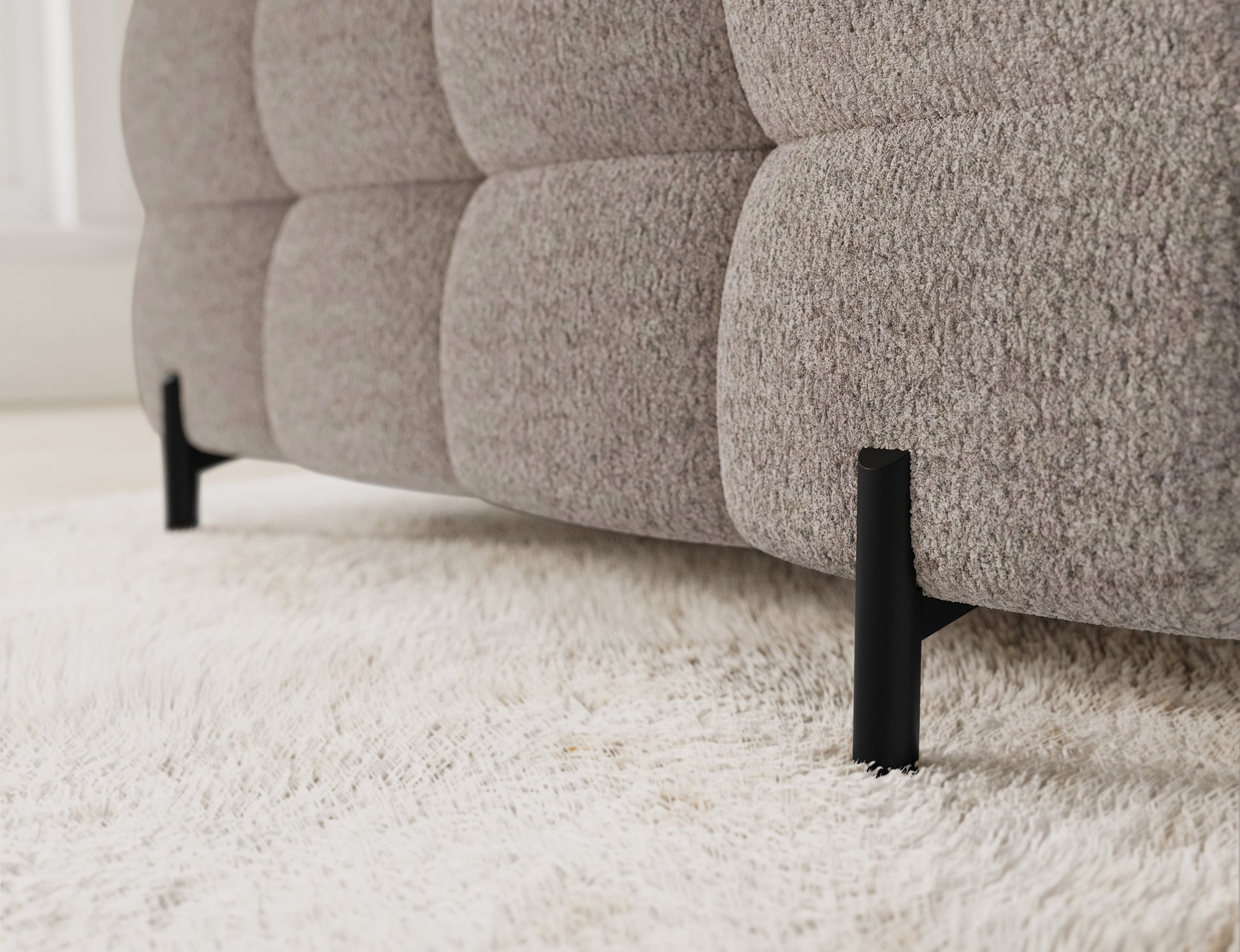 Zbliżenie na charakterystyczne pikowanie na bocznej części narożnika Fectory, z widocznymi nogami w kolorze czarnym.