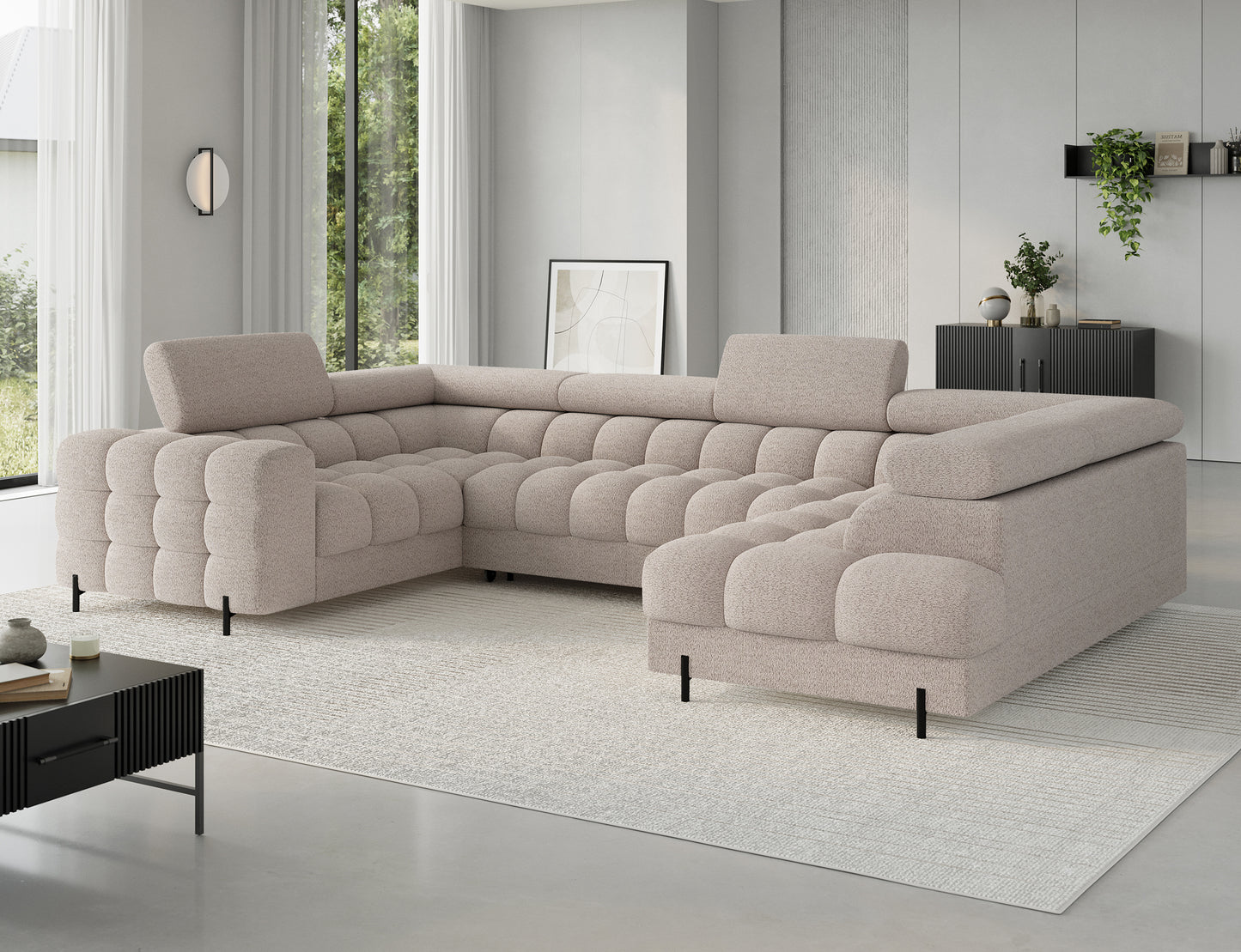 Narożnik Royal18 w kolorze jasnobeżowym w jasnym, nowoczesnym salonie z dużymi oknami. Proste linie i współczesny styl pasują do każdego wnętrza.