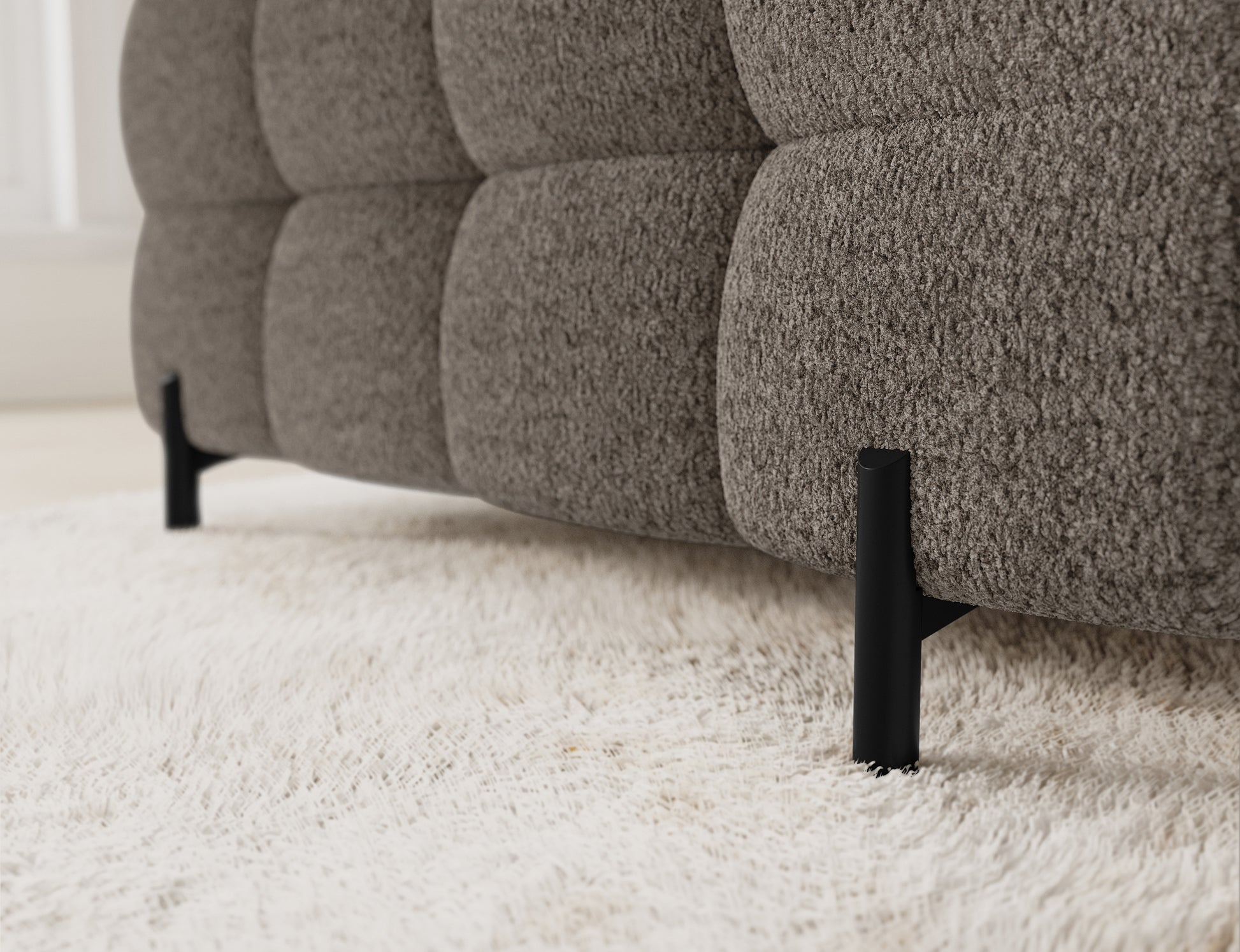 Detal pokazujący nogi narożnika z bliska – metalowe, w klasycznym, czarnym kolorze, podkreślające nowoczesny design mebla.