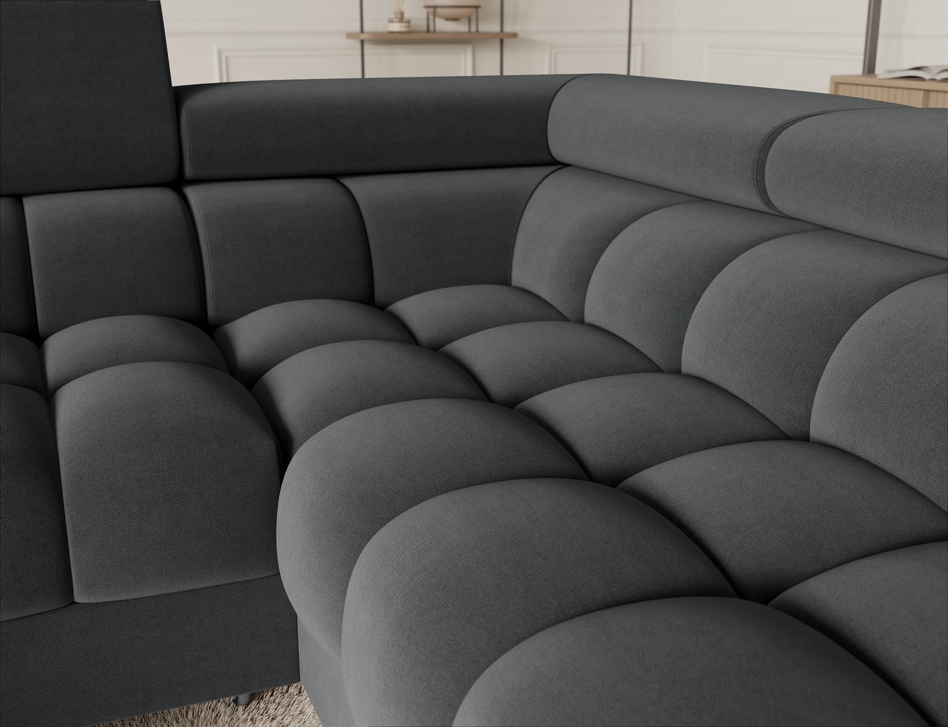 Eleganckie zbliżenie na narożnik Fectory w szarej tkaninie Sola 06, pokazujące charakterystyczne pikowanie oraz metalowe nogi, które podkreślają nowoczesny wygląd.