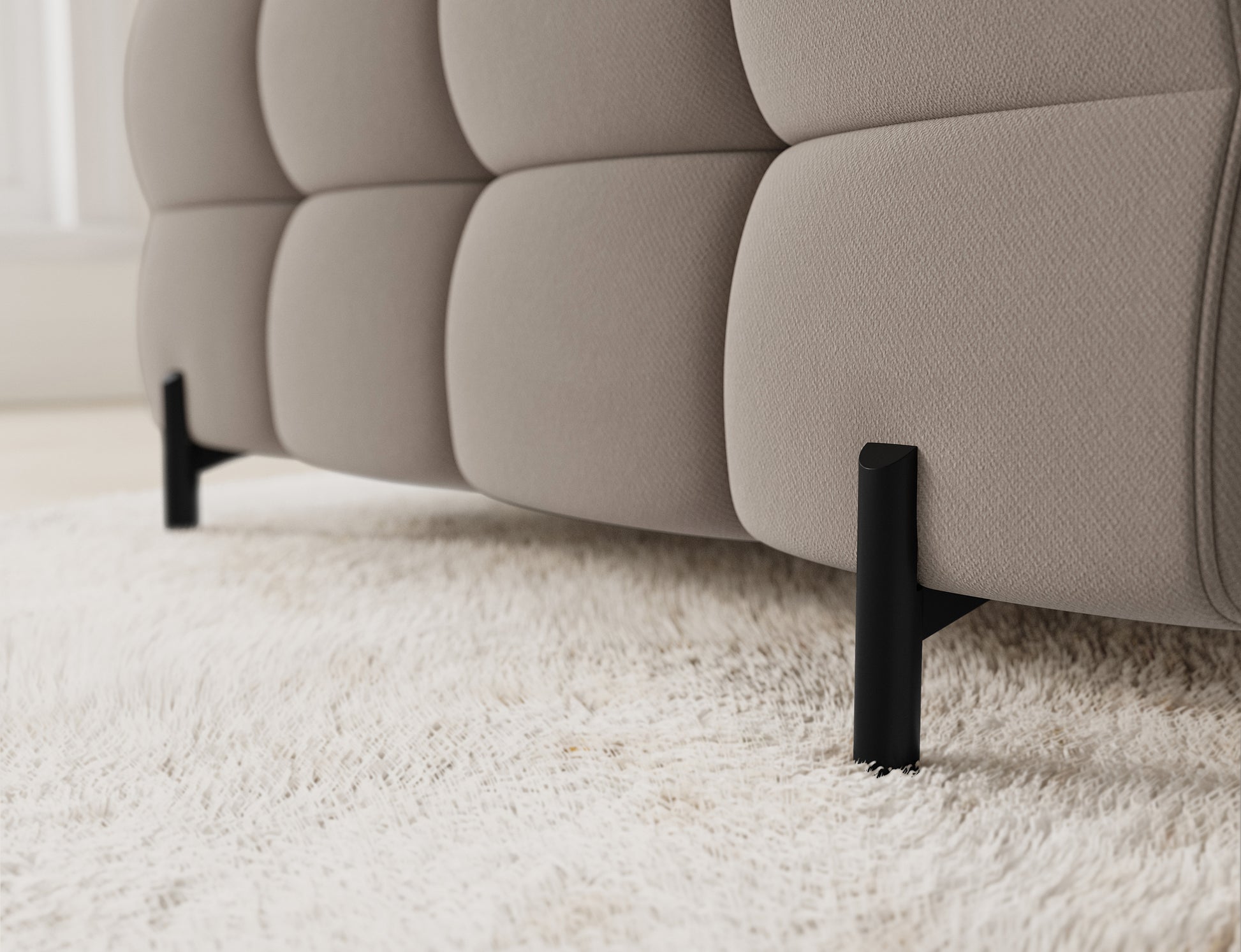 Zbliżenie na nogę sofy Fectory w tkaninie Sola 18 beżowy – nowoczesne, metalowe wykończenie.