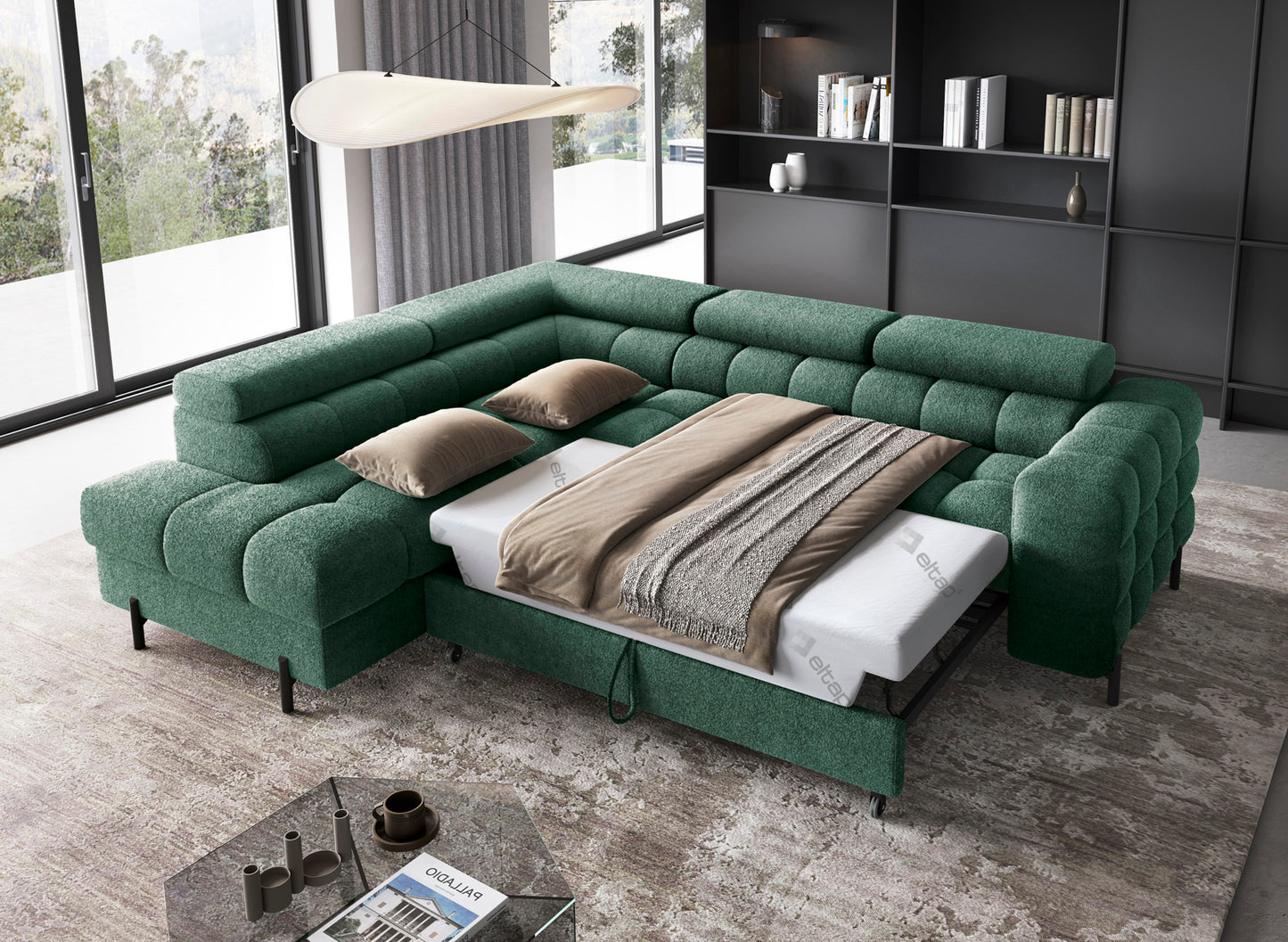Zielony narożnik Ferucce lewy w tkaninie Amore 35 z funkcją spania rozłożoną, na tle nowoczesnego wnętrza z dużymi oknami i regałem.