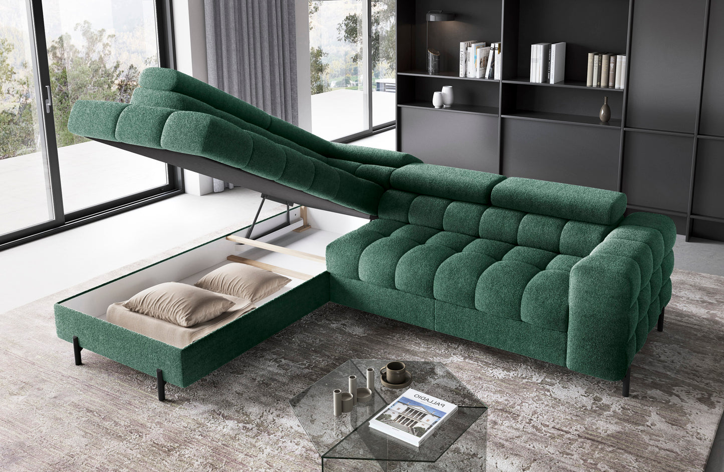 Zielony narożnik Ferucce lewy w tkaninie Amore 35 z otwartym pojemnikiem na pościel, w eleganckim salonie z regałem i dużymi oknami.