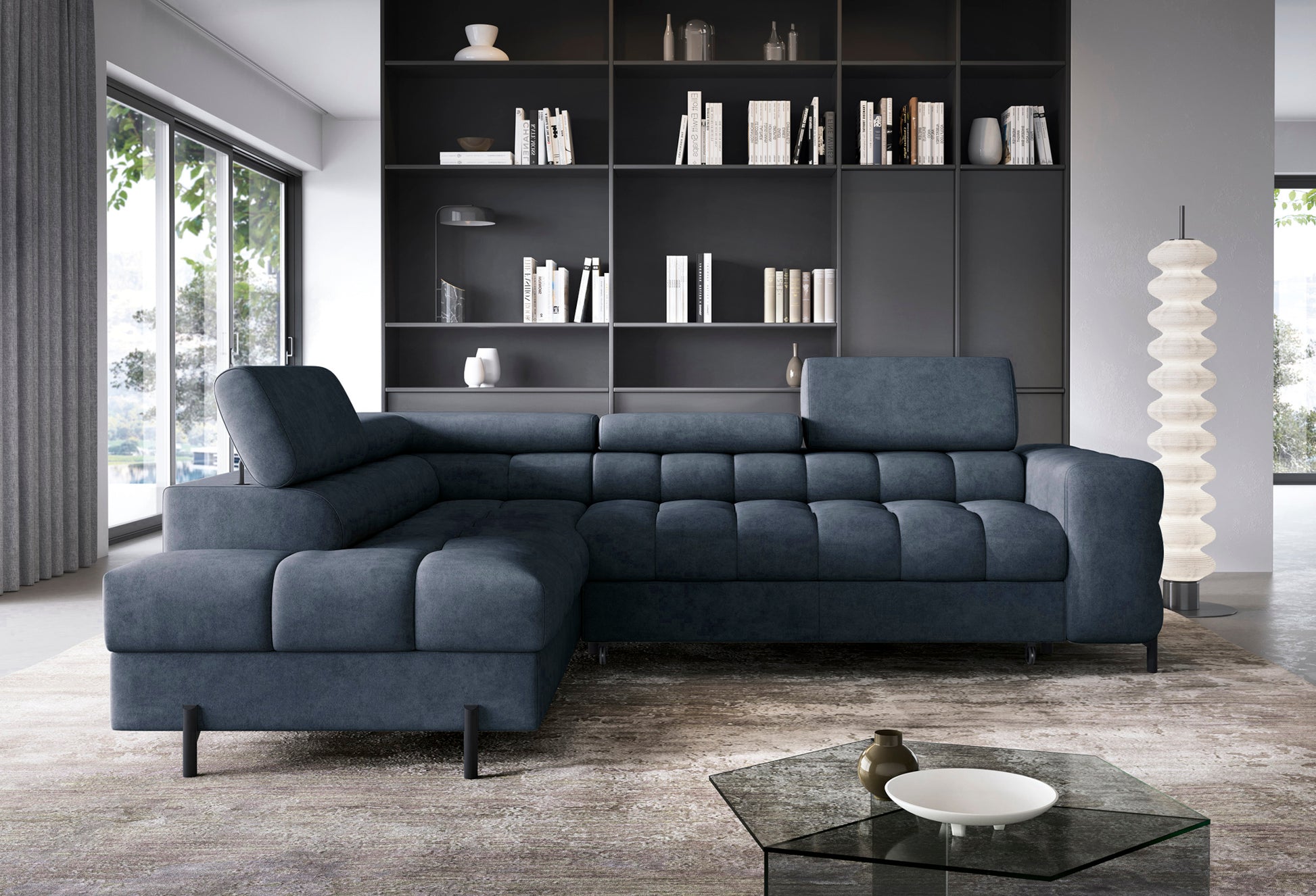 Narożnik Ferucce w granatowej tkaninie ustawiony w salonie z dużymi przeszkleniami i półką ścienną w stylu industrialnym.