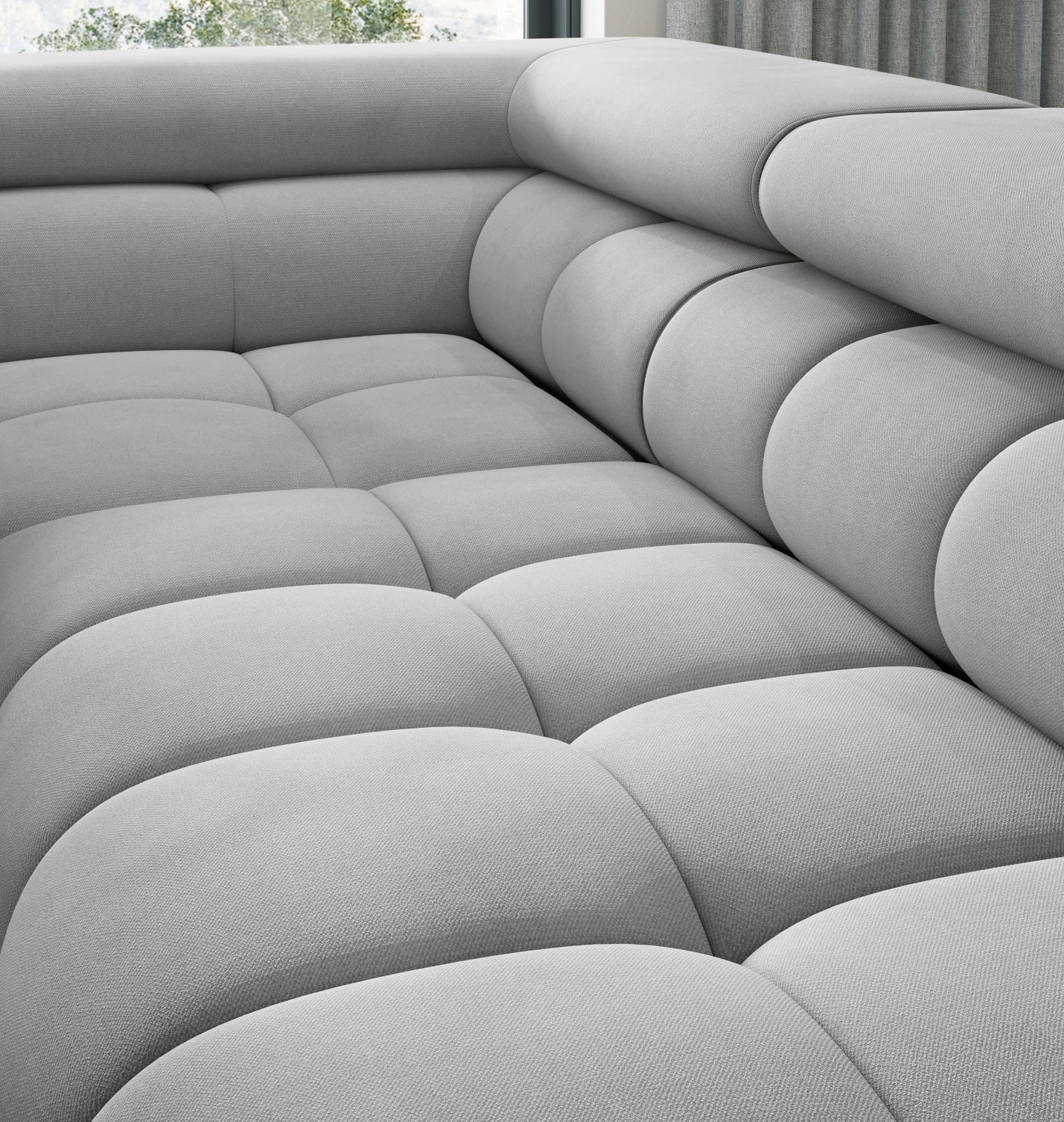 Miękkie i głębokie siedzisko narożnika Ferucce, pikowania i tapicerka jasnoszara Paros 05.