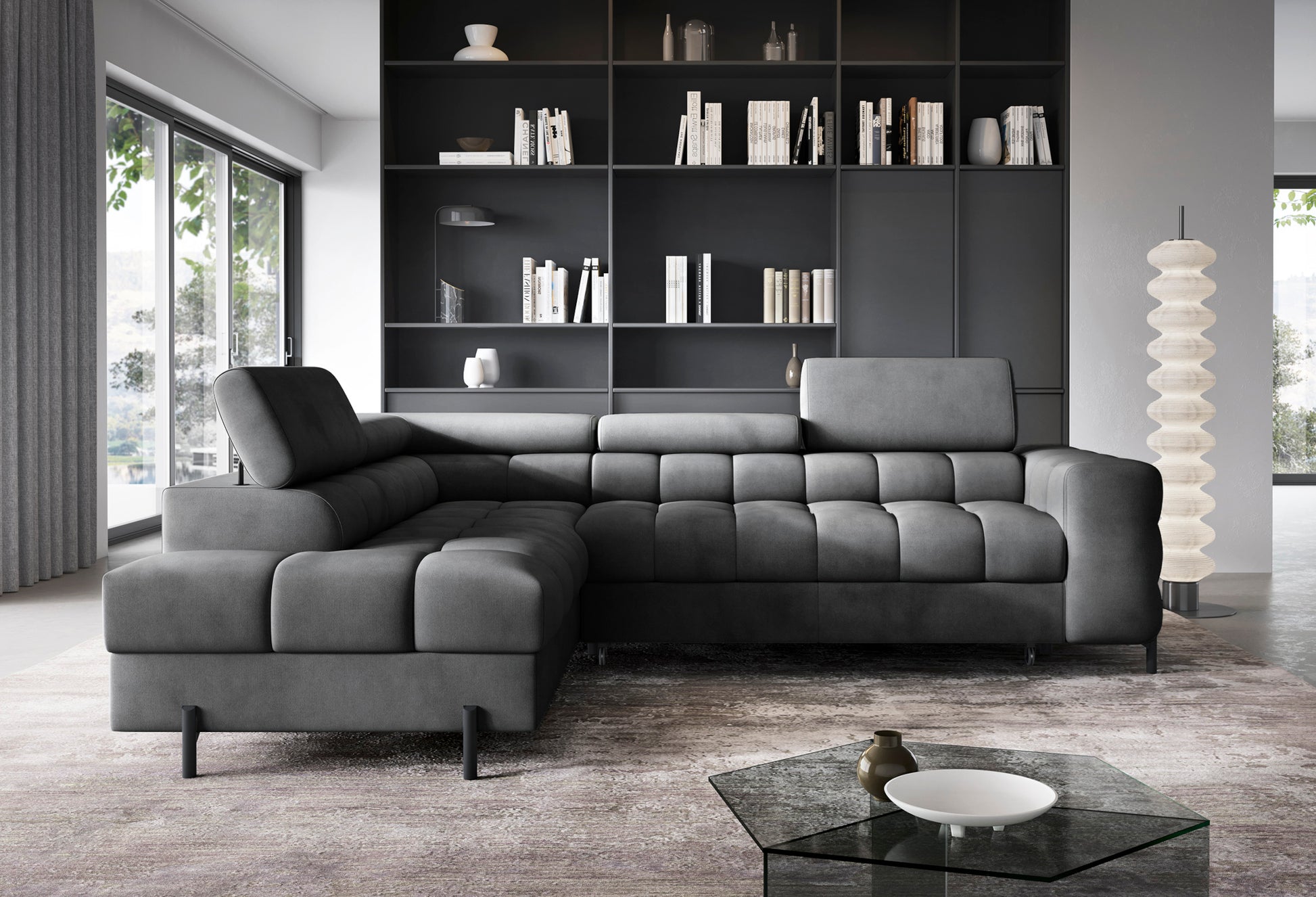 Narożnik Ferucce lewostronny w eleganckim wnętrzu – ciemnoszara tkanina Paros 06 kontrastująca z jasnym dywanem i czarną zabudową regału.