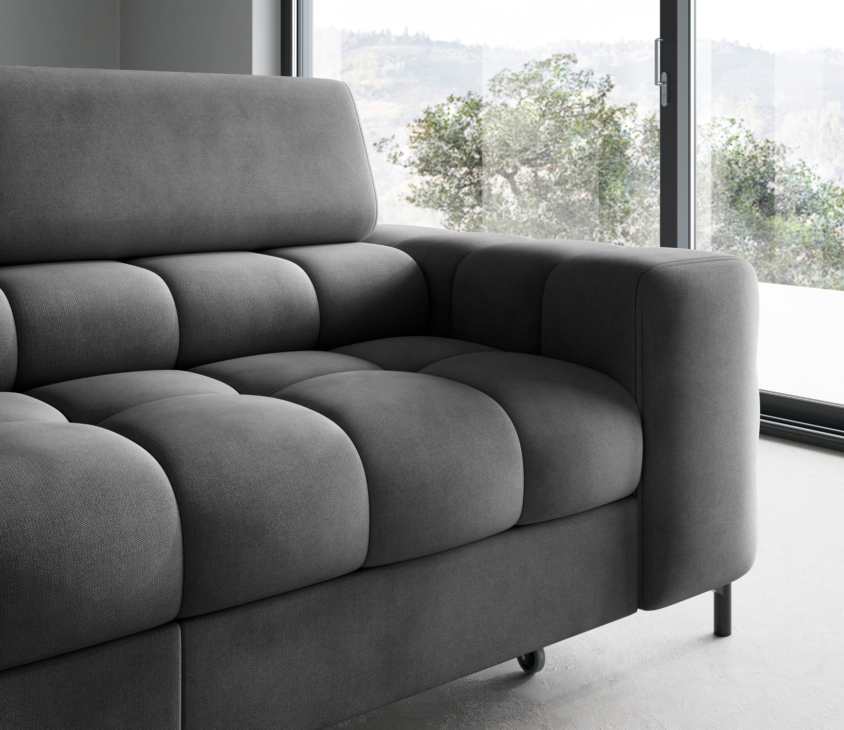 Zbliżenie na podłokietnik i fragment siedziska narożnika Ferucce w układzie lewym – ciemnoszara tkanina, zaokrąglone kształty i subtelne przeszycia podkreślające komfort użytkowania.