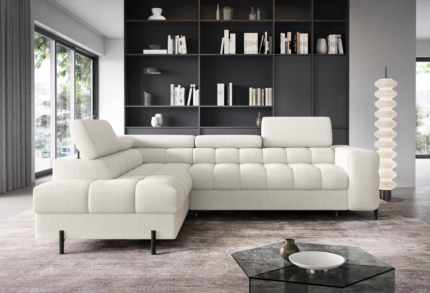 Narożnik Ferucce w aranżacji salonu – lewostronny układ w tkaninie Royal 01 biały na tle ciemnej zabudowy ściennej i dużych przeszkleń.
