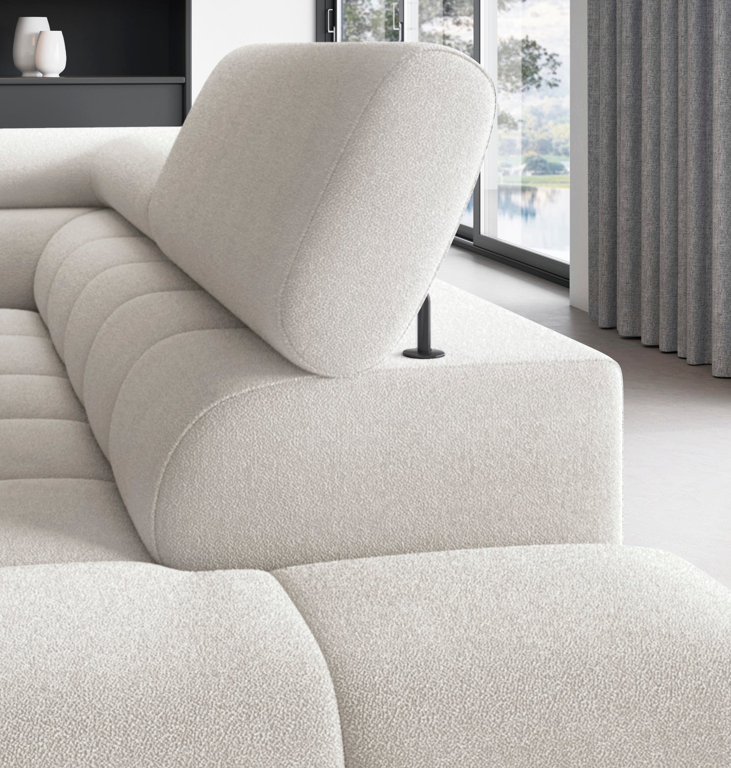 Zbliżenie na regulowany zagłówek narożnika Ferucce w tkaninie Amore 01, ustawionego w jasnym, nowoczesnym salonie.