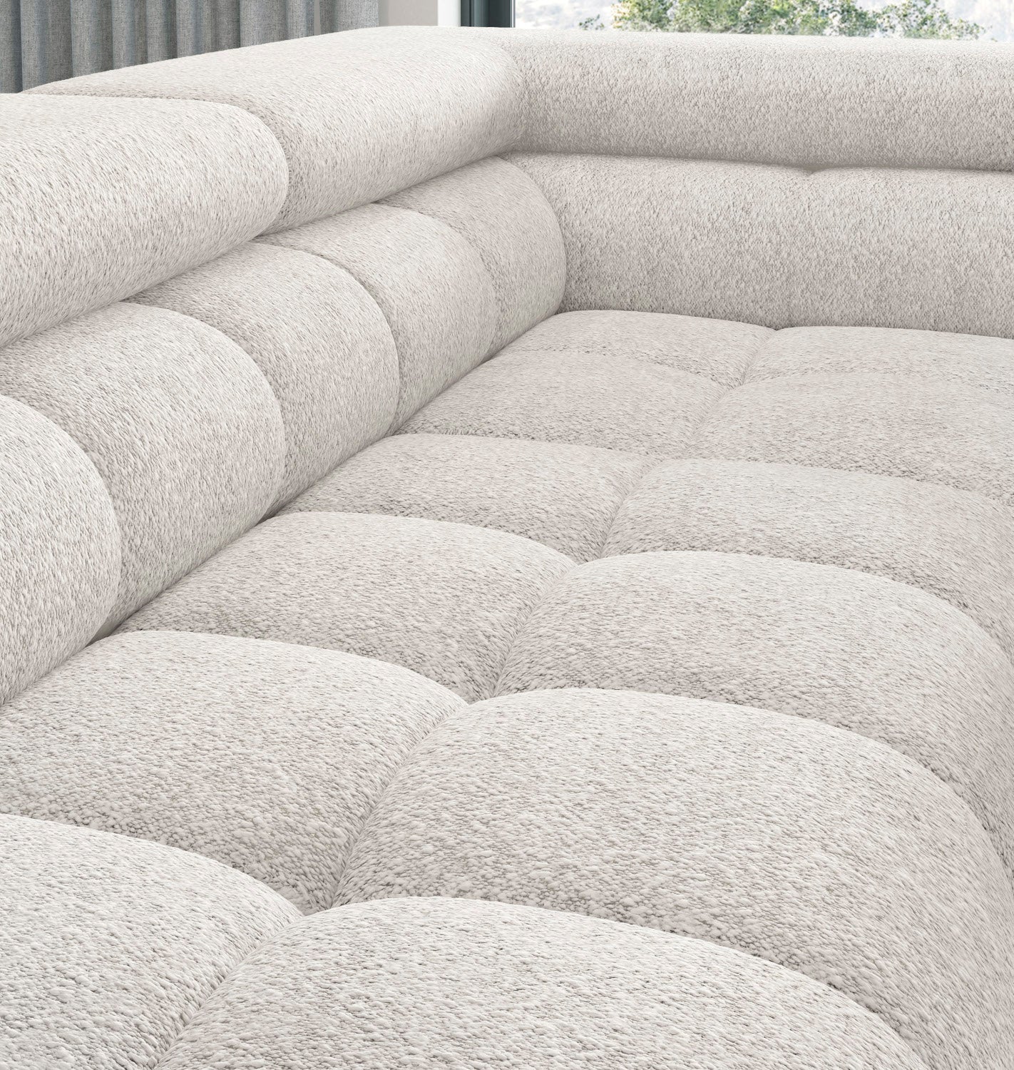 Zbliżenie na powierzchnię siedziska narożnika Ferucce Royal 01 biały, pokazujące miękkie, głęboko pikowane siedziska i tapicerkę o strukturze boucle.