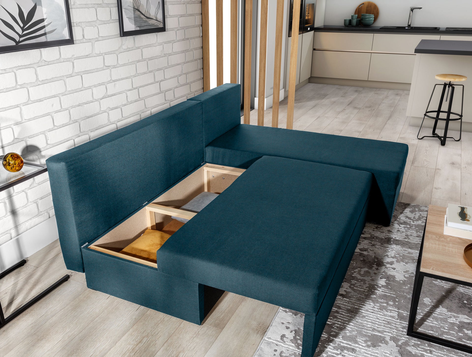 Narożnik Gino w kolorze Nube 40 granatowy z otwartym pojemnikiem na pościel, w przestronnym, nowoczesnym wnętrzu.