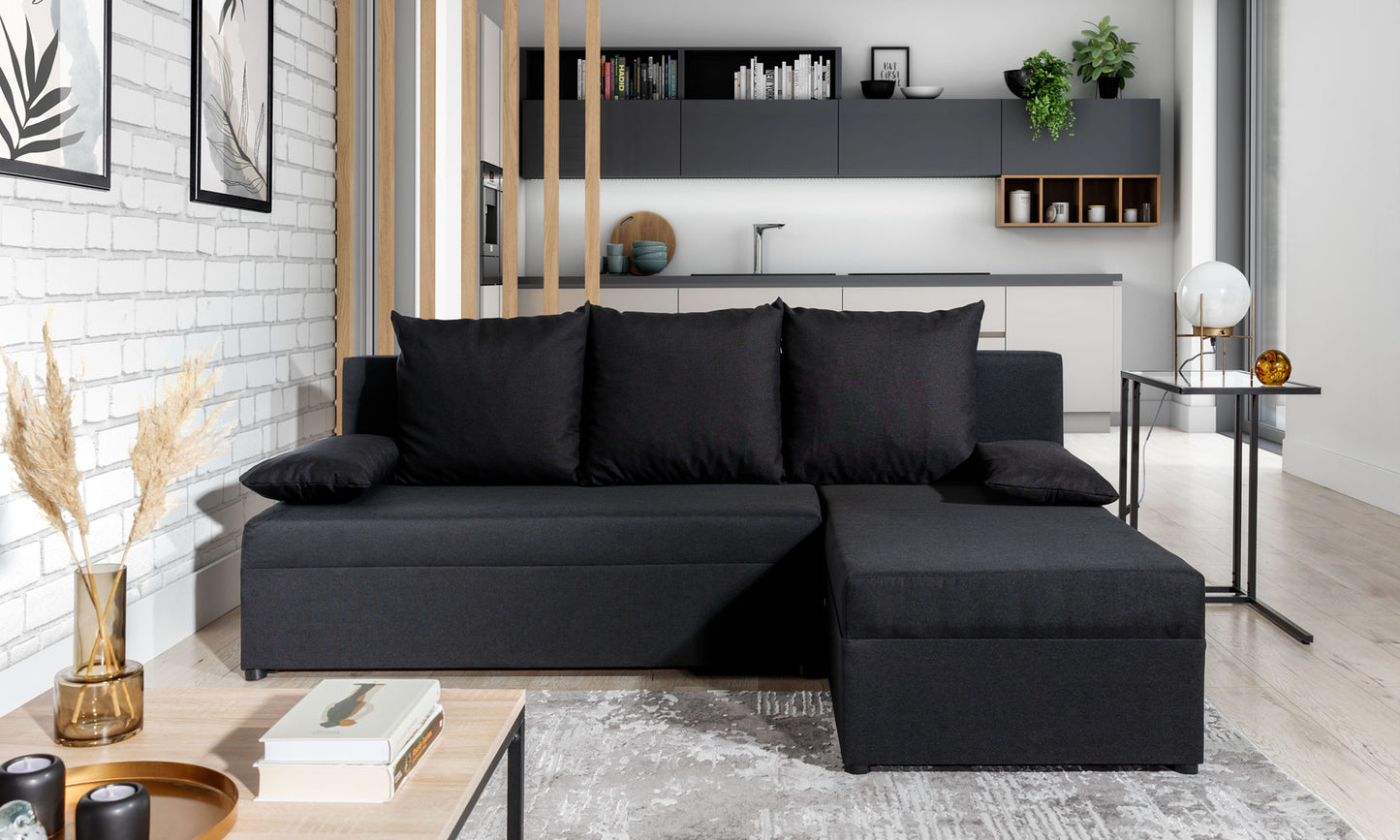 Narożnik Gino w kolorze Sawana 14 czarny, uniwersalny układ, ustawiony w nowoczesnym salonie z jasnym wystrojem i kuchnią w tle.