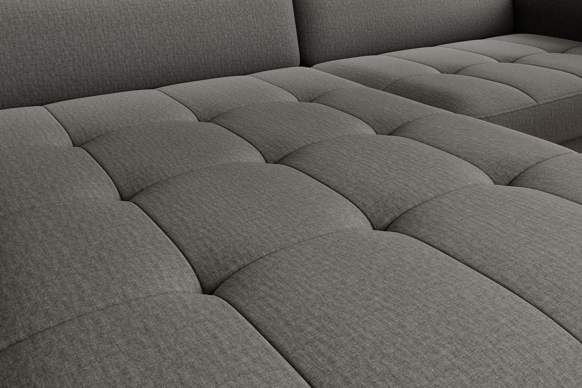 Zbliżenie na pikowaną tkaninę – detal siedziska narożnika Gomsi w kolorze szarym Manhattan 06, wielowymiarowy wzór przeszyć.