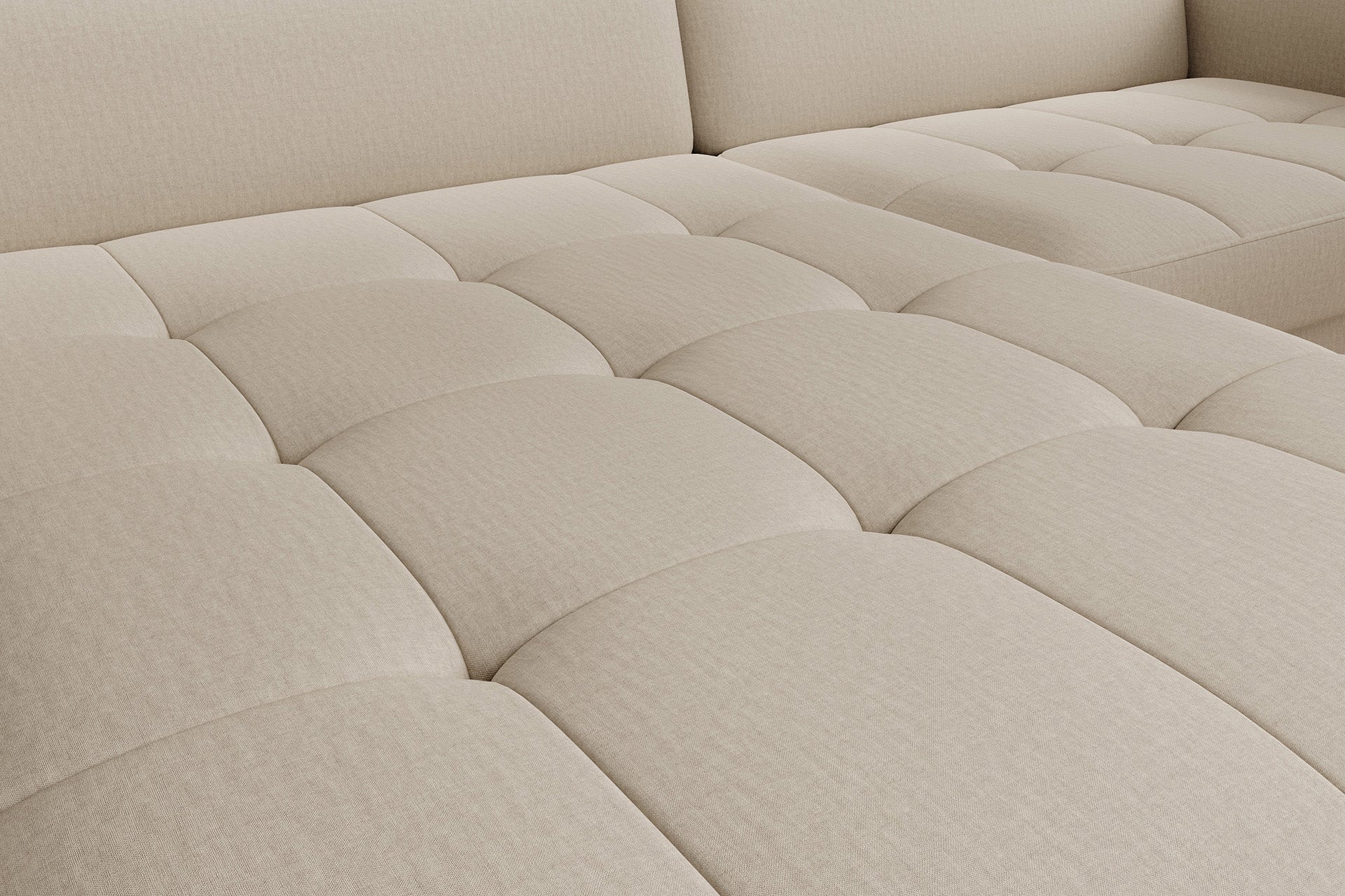 Zbliżenie na pikowane siedzisko – detal faktury tkaniny i regularnych przeszyć narożnika Gomsi Manhattan 18 jasnobeżowy.