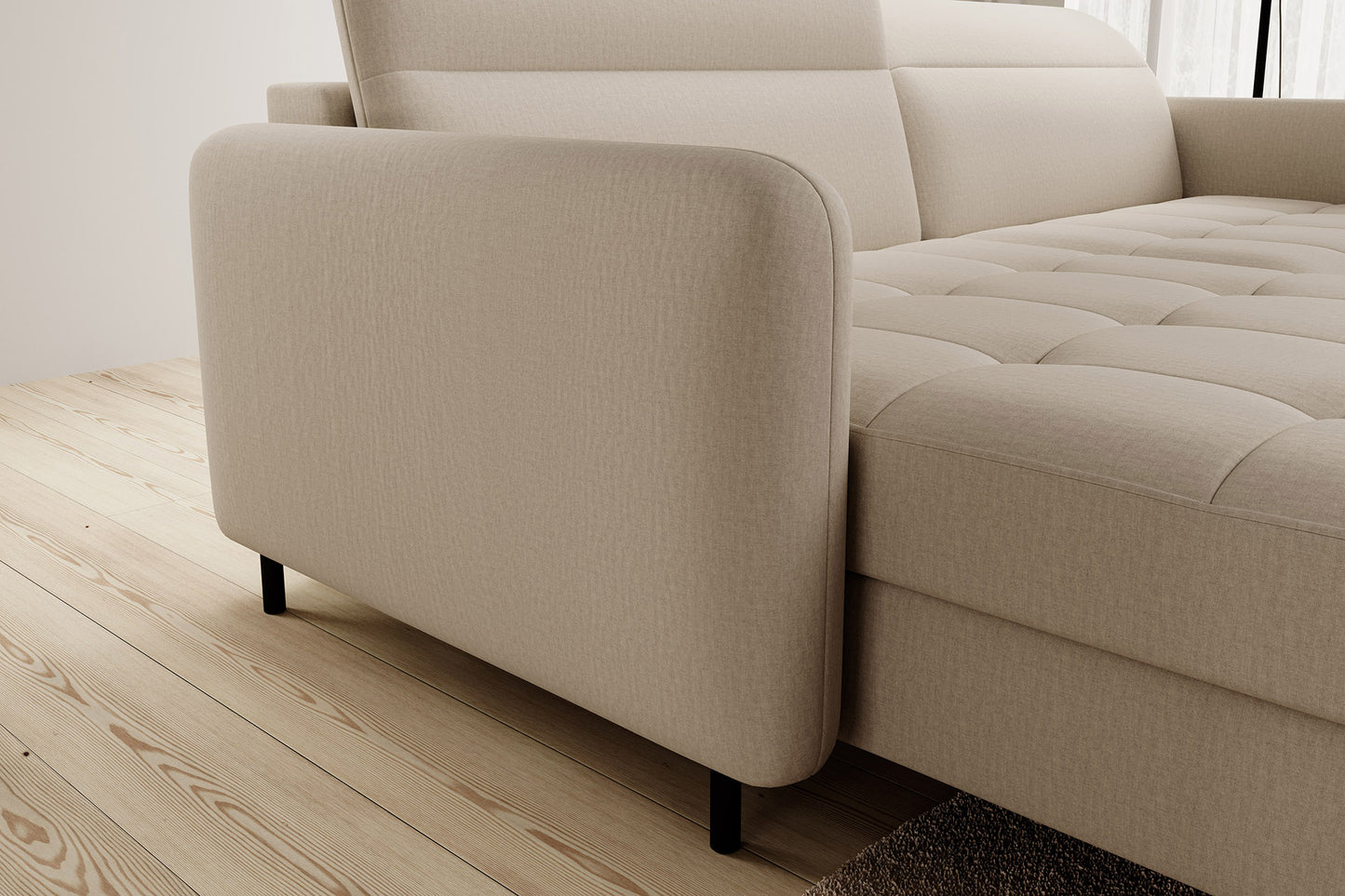 Detal podłokietnika i nóżki – zaokrąglony boczny podłokietnik narożnika Gomsi Manhattan 18 jasnobeżowy (układ lewy) oraz smukła czarna metalowa nóżka na jasnej podłodze.