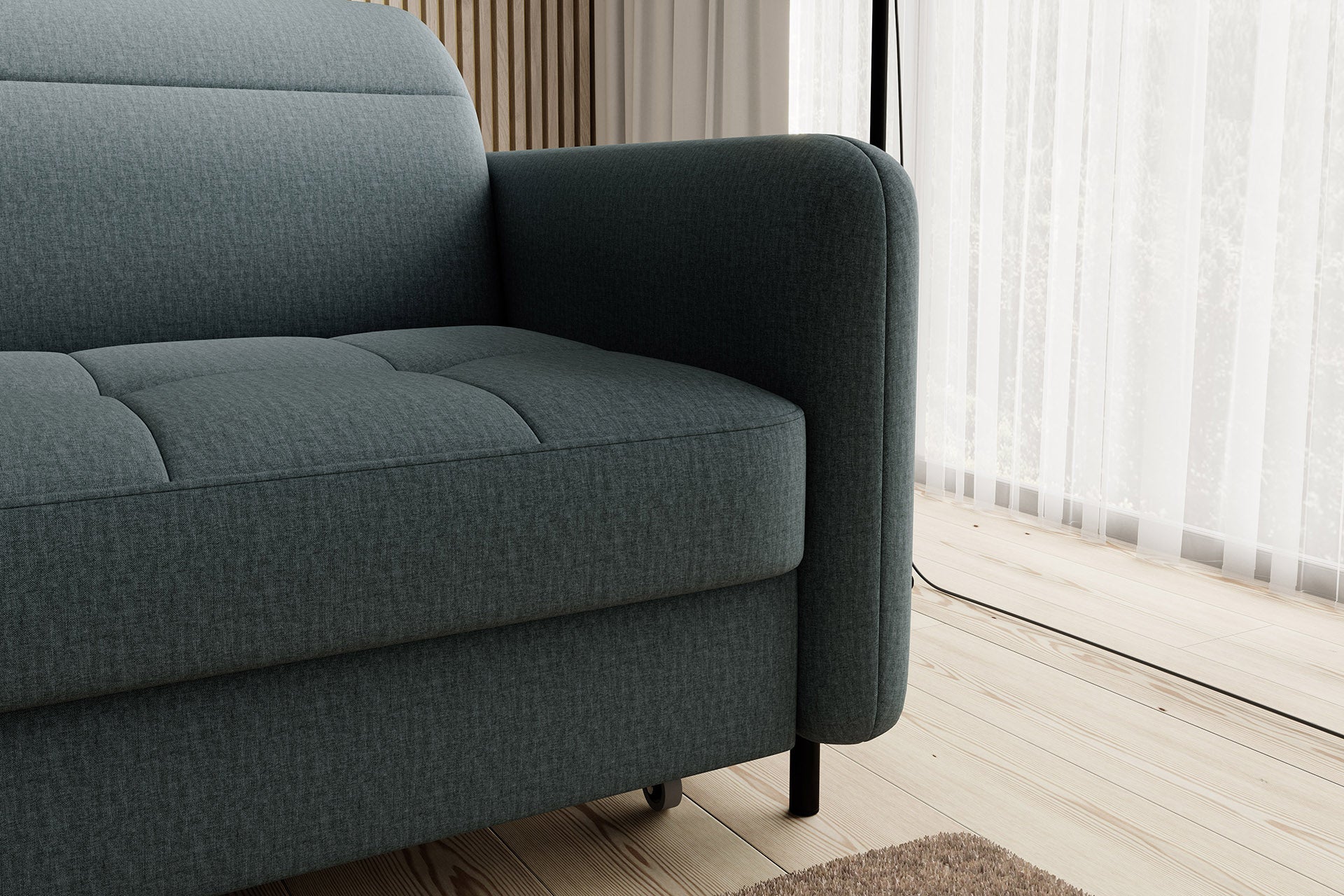 Detal prawego podłokietnika i nóżki narożnika Gomsi Manhattan 38 zielony, układ lewy – zbliżenie na prawy podłokietnik, widoczne kółko podporowe szezlongi i metalową nogę.