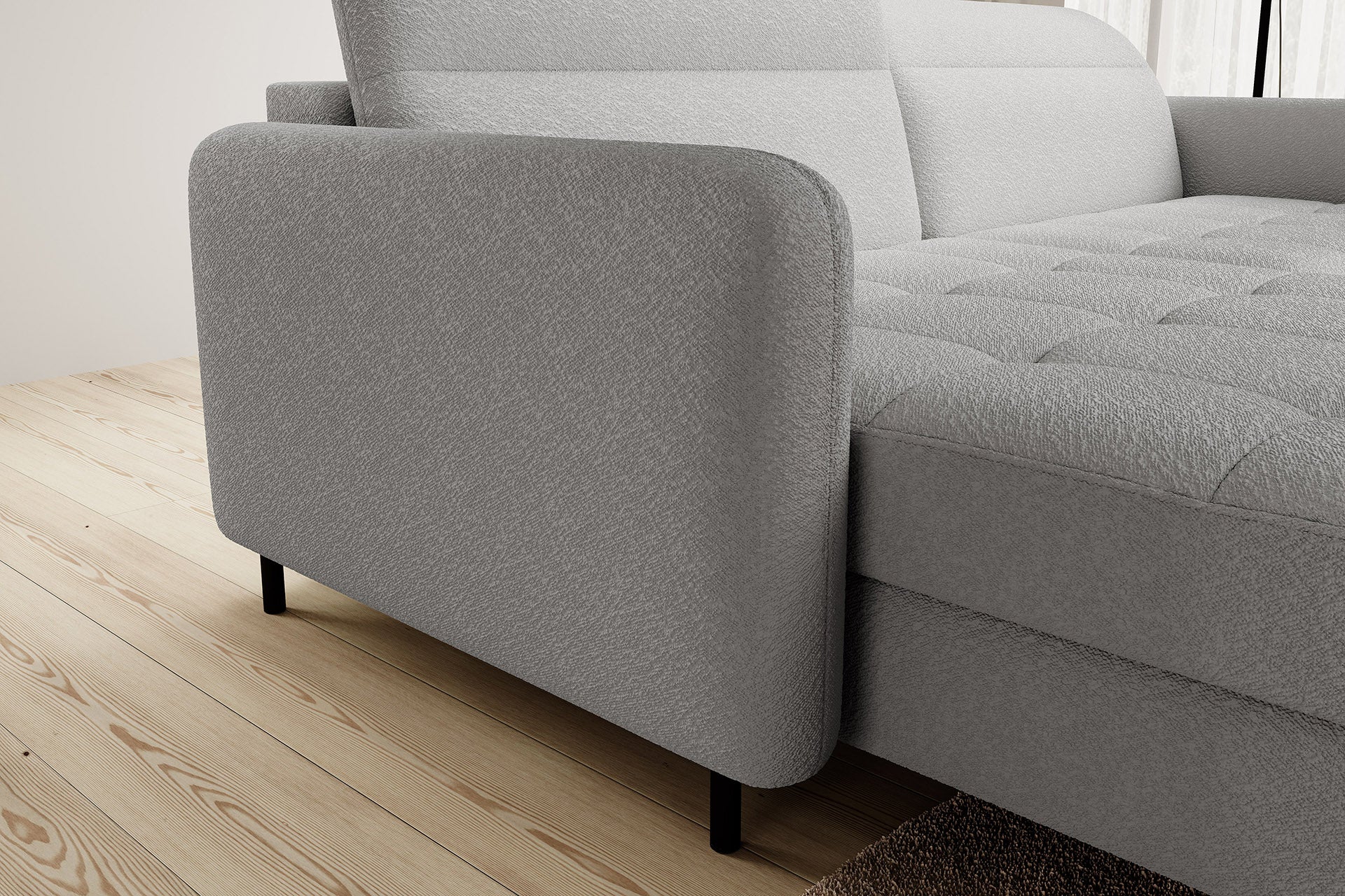 Zbliżenie na zaokrąglony lewy podłokietnik narożnika Gomsi Royal 04 w kolorze szarym, z wyraźnie widoczną czarną metalową nóżką na jasnej drewnianej podłodze.