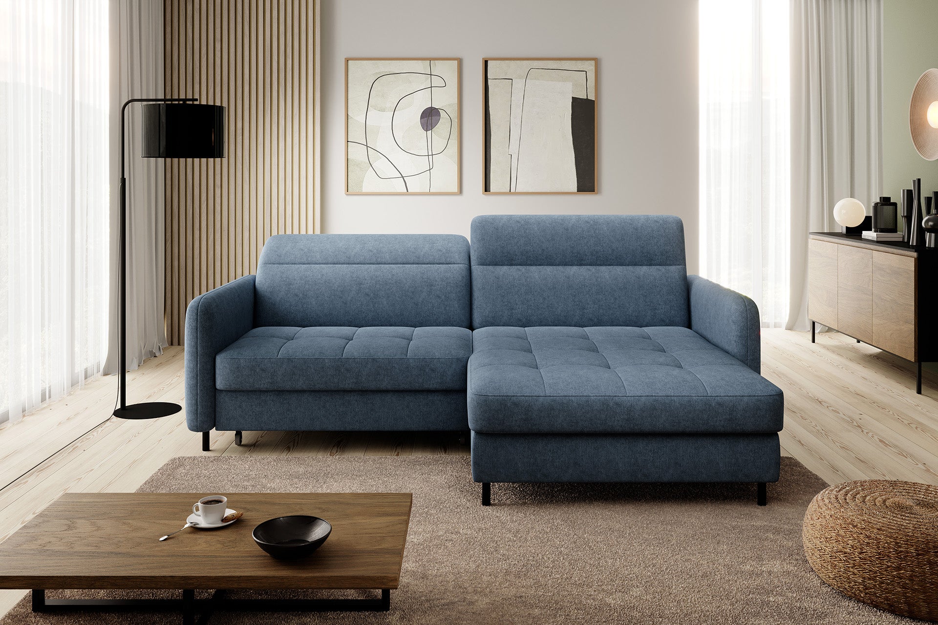 Narożnik Gomsi Raquel 40 w niebieskiej tkaninie we współczesnym salonie z drewnianą podłogą, stolikiem kawowym i abstrakcyjną dekoracją ściany, ustawiony przodem do obserwatora.