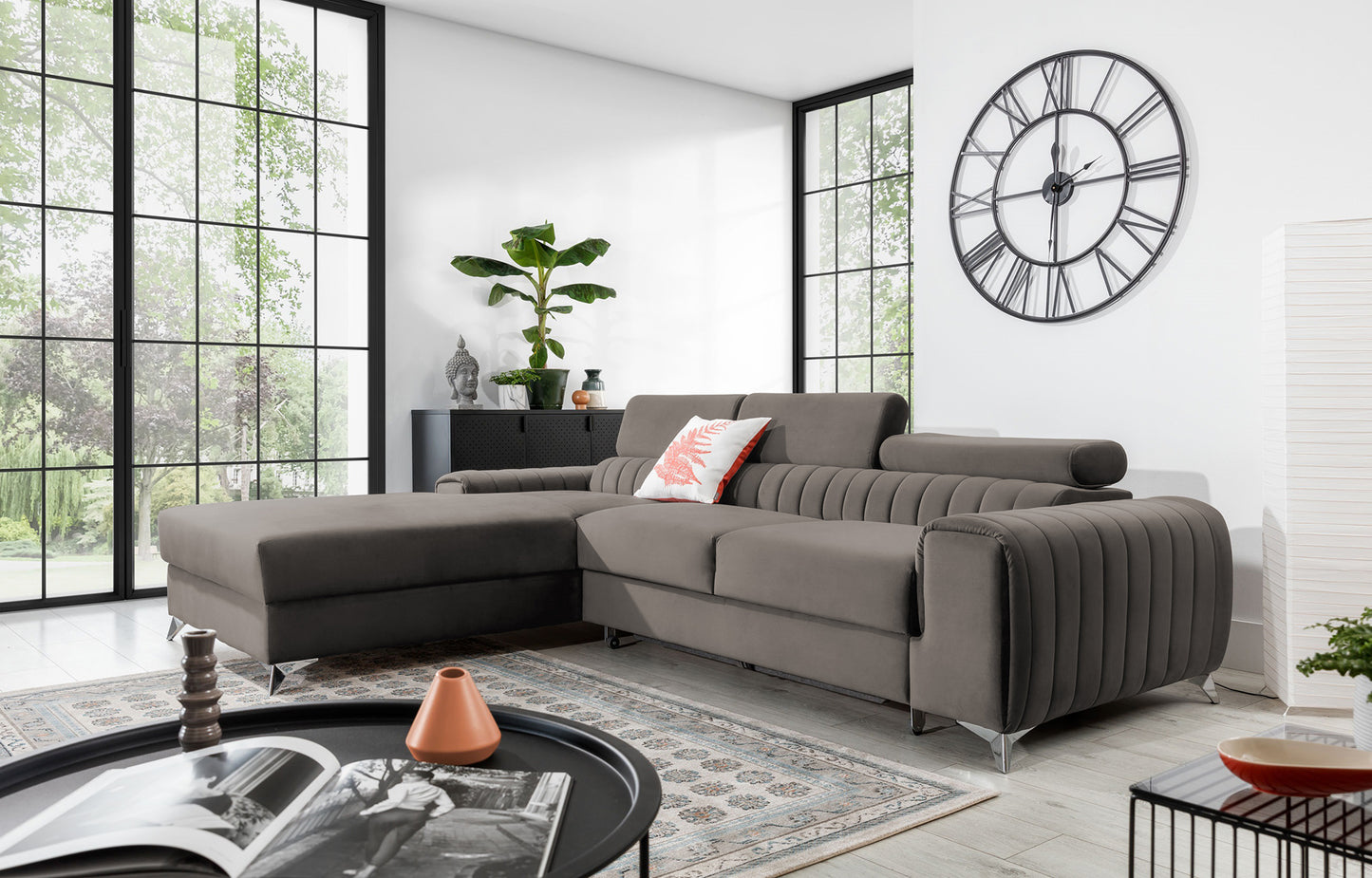 Narożnik Grayson Loco 04 jasnoszary w aranżacji salonu z dużymi oknami i dekoracyjną poduszką – elegancki układ lewy.