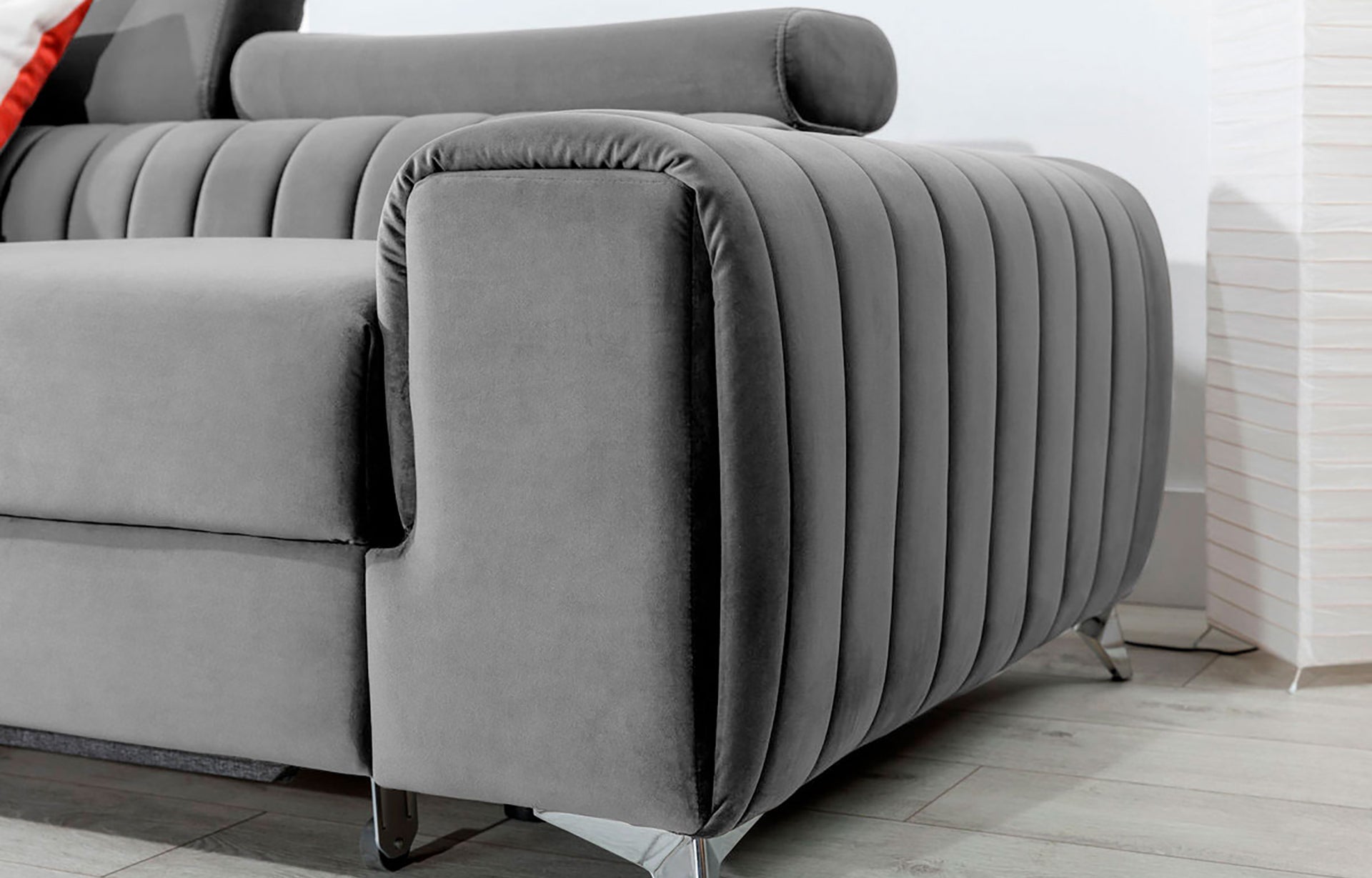 Zbliżenie na podłokietnik narożnika Grayson Nube 03 jasnoszary – miękka tapicerka i eleganckie pionowe przeszycia.