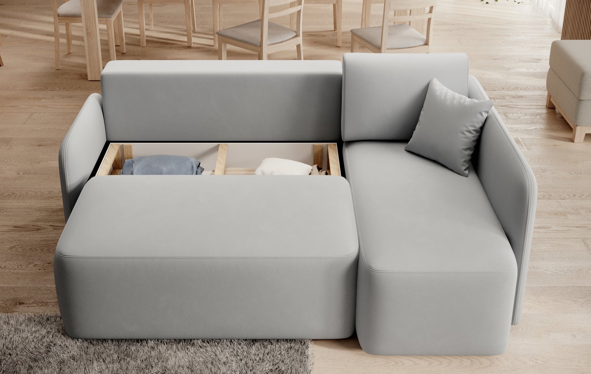 Pojemnik na pościel w narożniku Hadson jasnoszarym, otwarty i ukazujący przestrzeń do przechowywania.