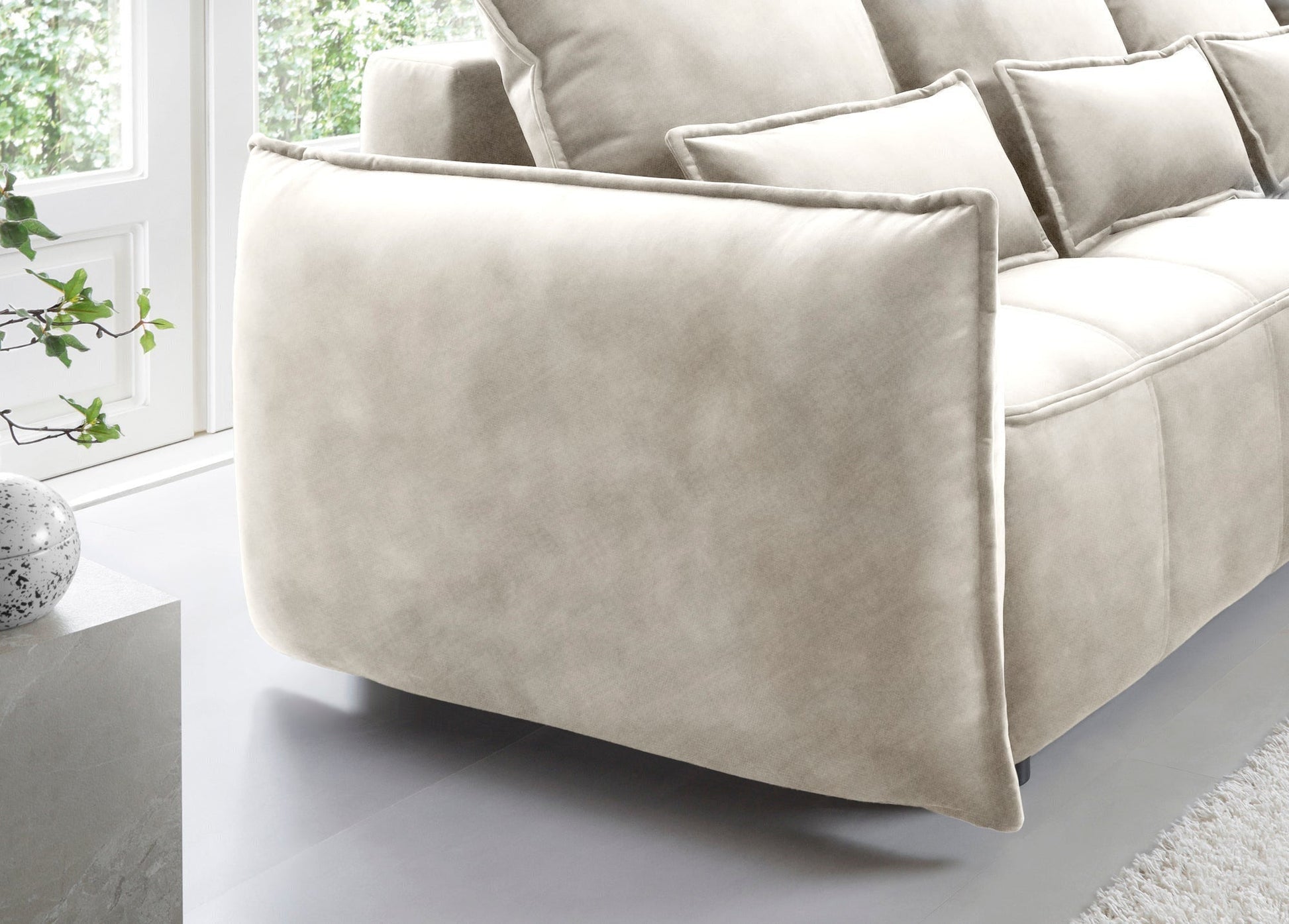 Widok na prawy boczny panel narożnika Campo w kolorze Manhattan 18 jasnobeżowy, podkreślający zaokrąglony profil i jednolitą tonację tkaniny.