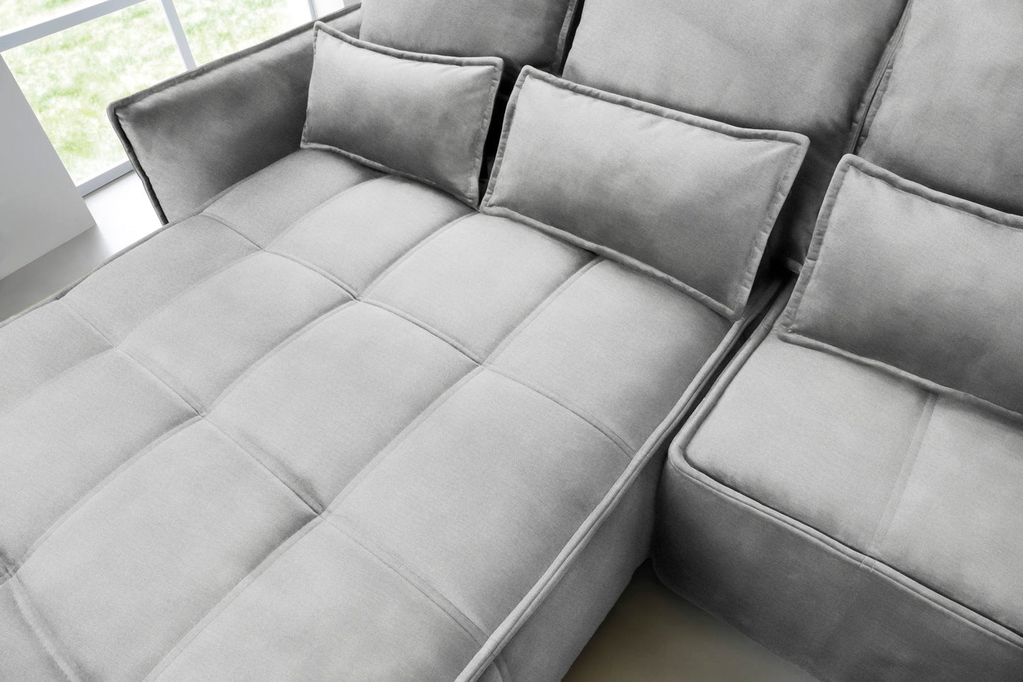 Zbliżenie na pikowane siedzisko i prostokątne poduszki narożnika Campo w układzie lewym, tkanina Nube 03 jasnoszara.