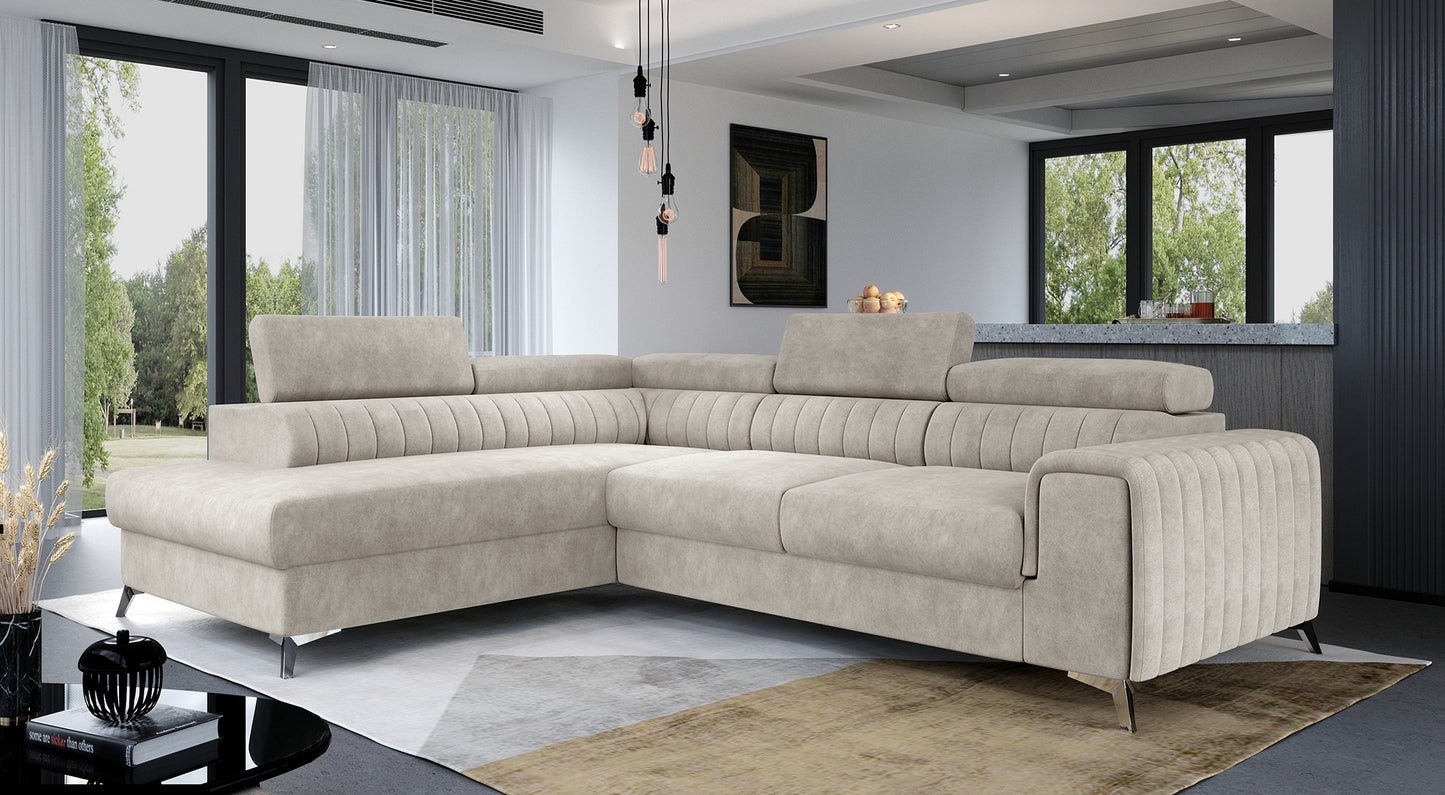 Narożnik Laurence w kolorze Dora 21 beżowy, układ lewy, ustawiony w przestronnym salonie z dużymi oknami i jasnym wystrojem.