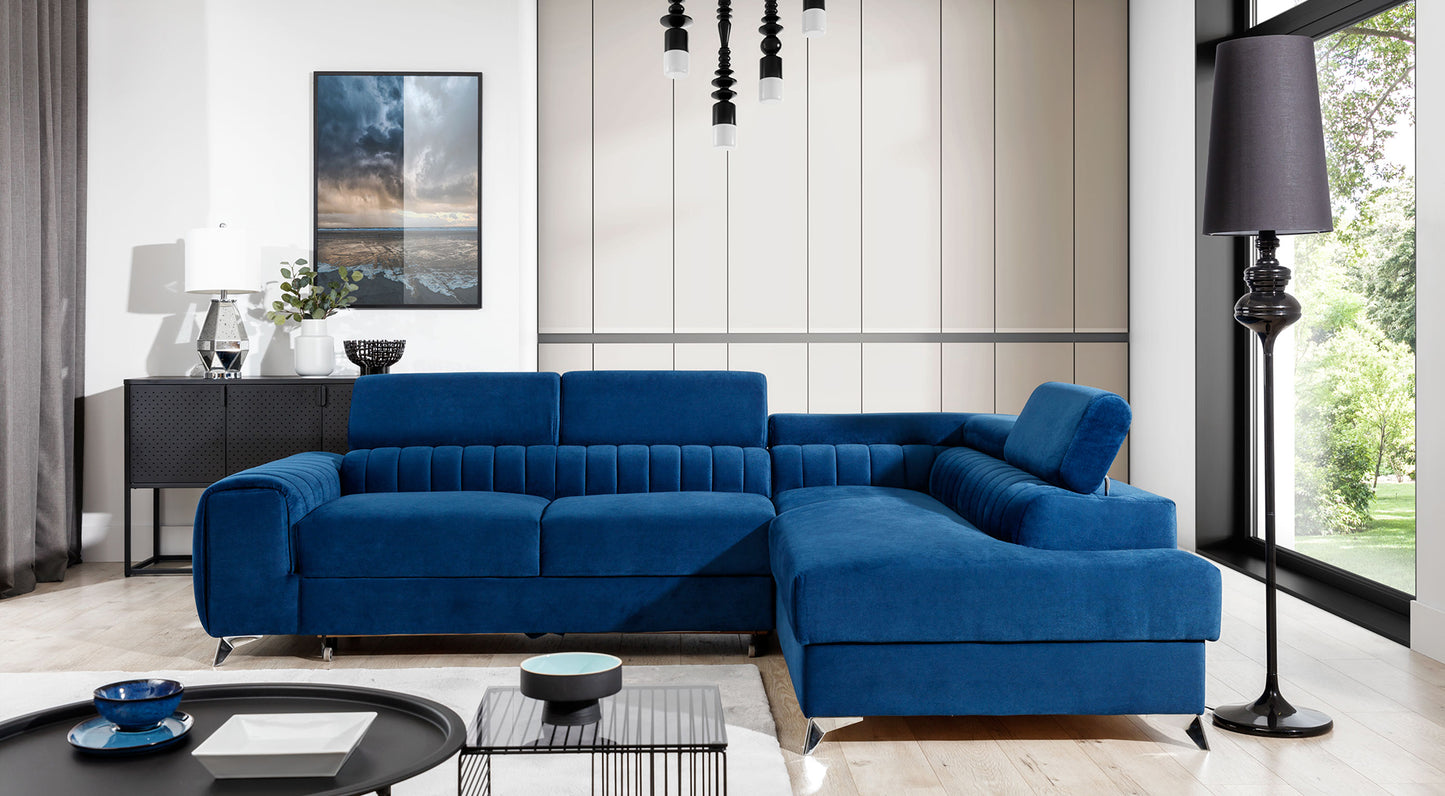 Narożnik Laurence w kolorze Kronos 09 granatowy, układ prawy, ustawiony w nowoczesnym salonie z dużymi oknami i jasnym wystrojem.