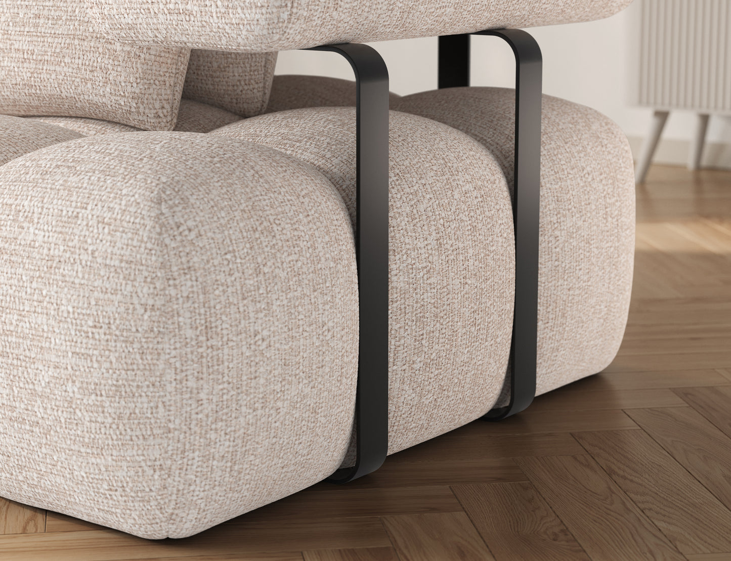 Zdjęcie prezentuje detal narożnika Levvi w tkaninie Bazalt 18 beżowy – widoczne są czarne metalowe elementy oraz staranne wykończenie tapicerki.