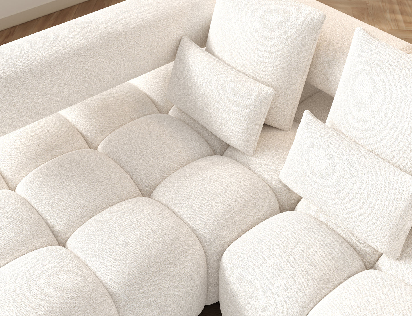 Widok górny narożnika Levvi w białej tkaninie Jaffray 01 – poduszki i siedzisko o charakterystycznym, miękkim pikowaniu.