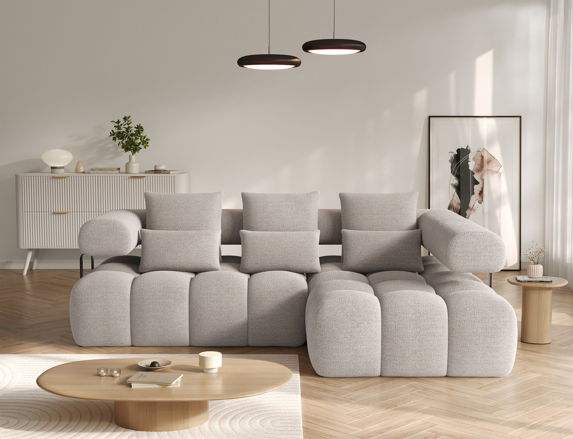 Narożnik Levvi prawy boucle Royal 18 jasnobeżowy, widok od frontu w jasnym salonie, komplet poduszek dekoracyjnych, funkcja Relax