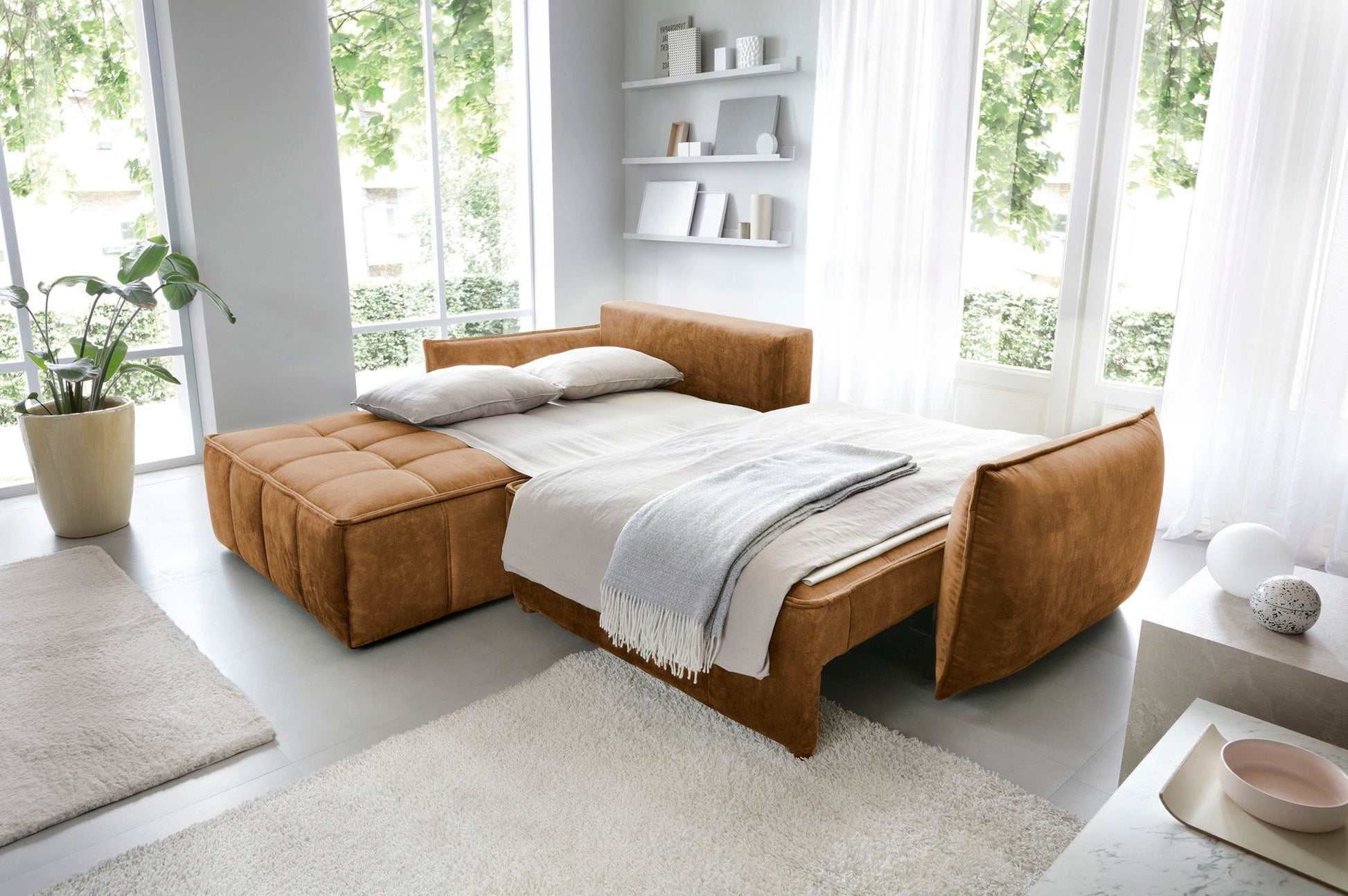 Narożnik Campo w kolorze Toscany 45 miodowy w układzie lewym – rozłożony moduł siedziska przekształcony w łóżko z pościelą i dwoma poduszkami.