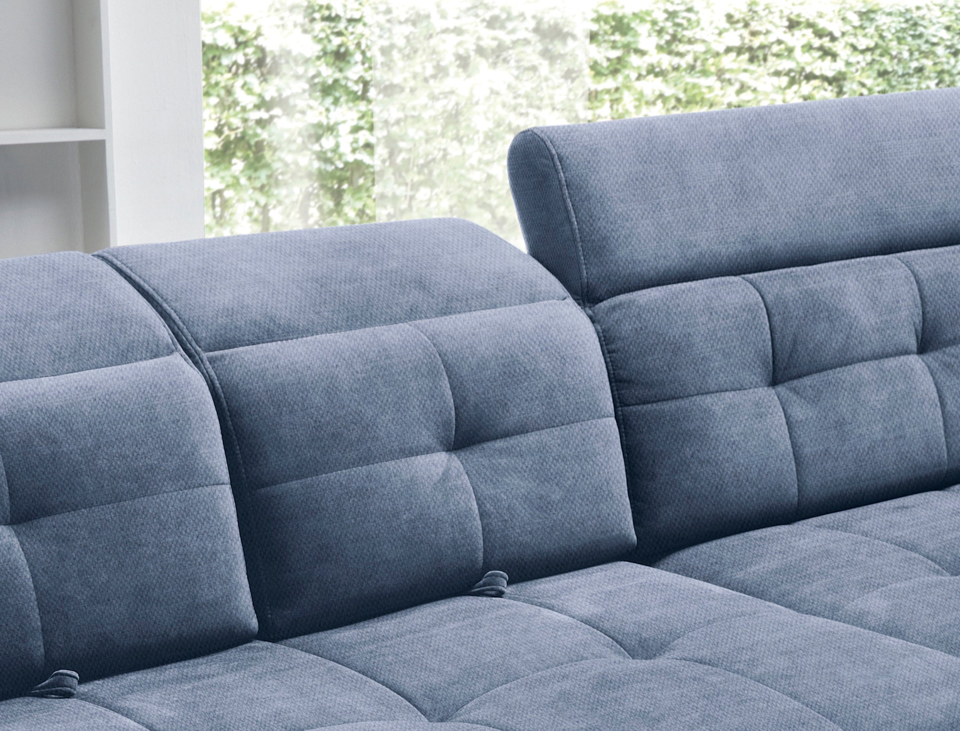 Zbliżenie na pikowane siedzisko i miękko wyprofilowany podłokietnik narożnika Inferne Raquel 40 niebieskiego w układzie prawym.