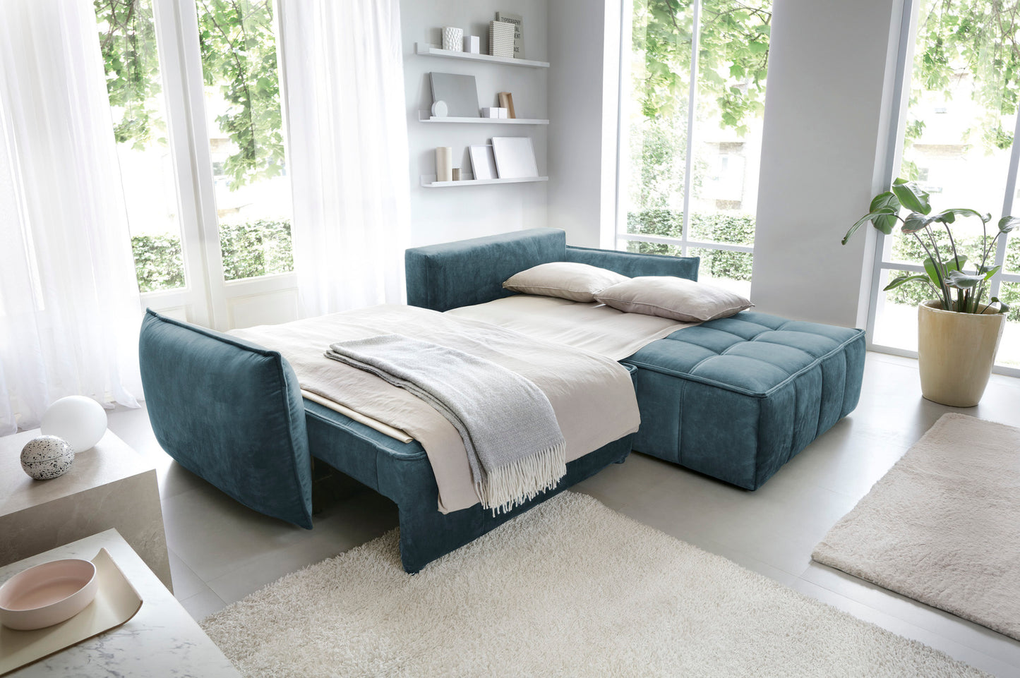 Narożnik Campo w kolorze Toscany 40 niebieski w układzie prawym – kąt widzenia z boku w eleganckim wnętrzu z miękkim dywanem i stolikiem kawowym.