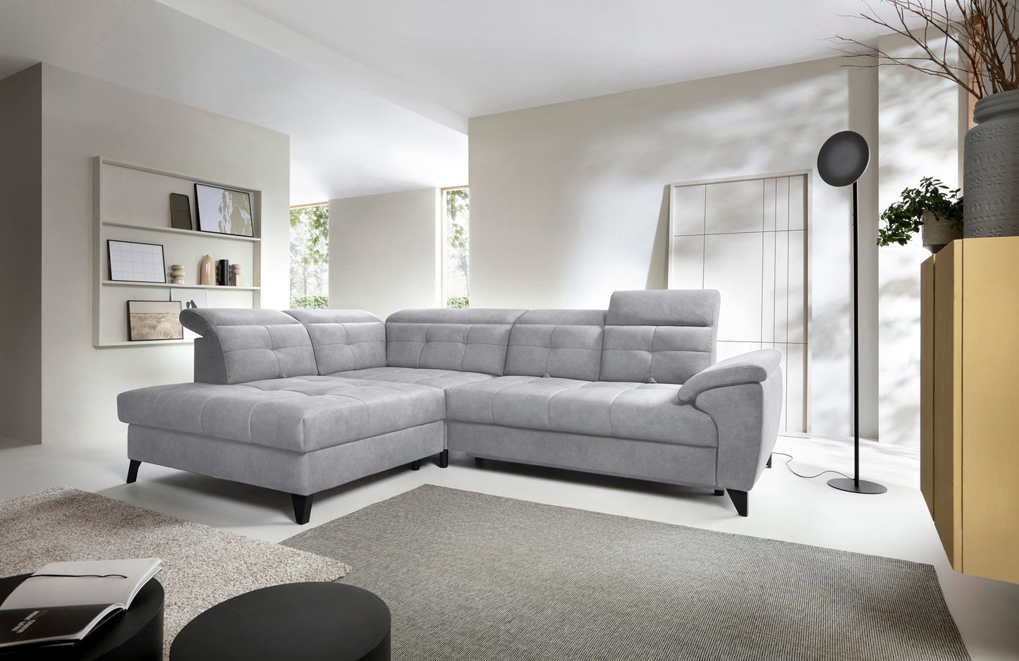 Narożnik Inferne Aura 04 szary w układzie lewym ustawiony w jasnym salonie obok stojącej lampy i dywanu.