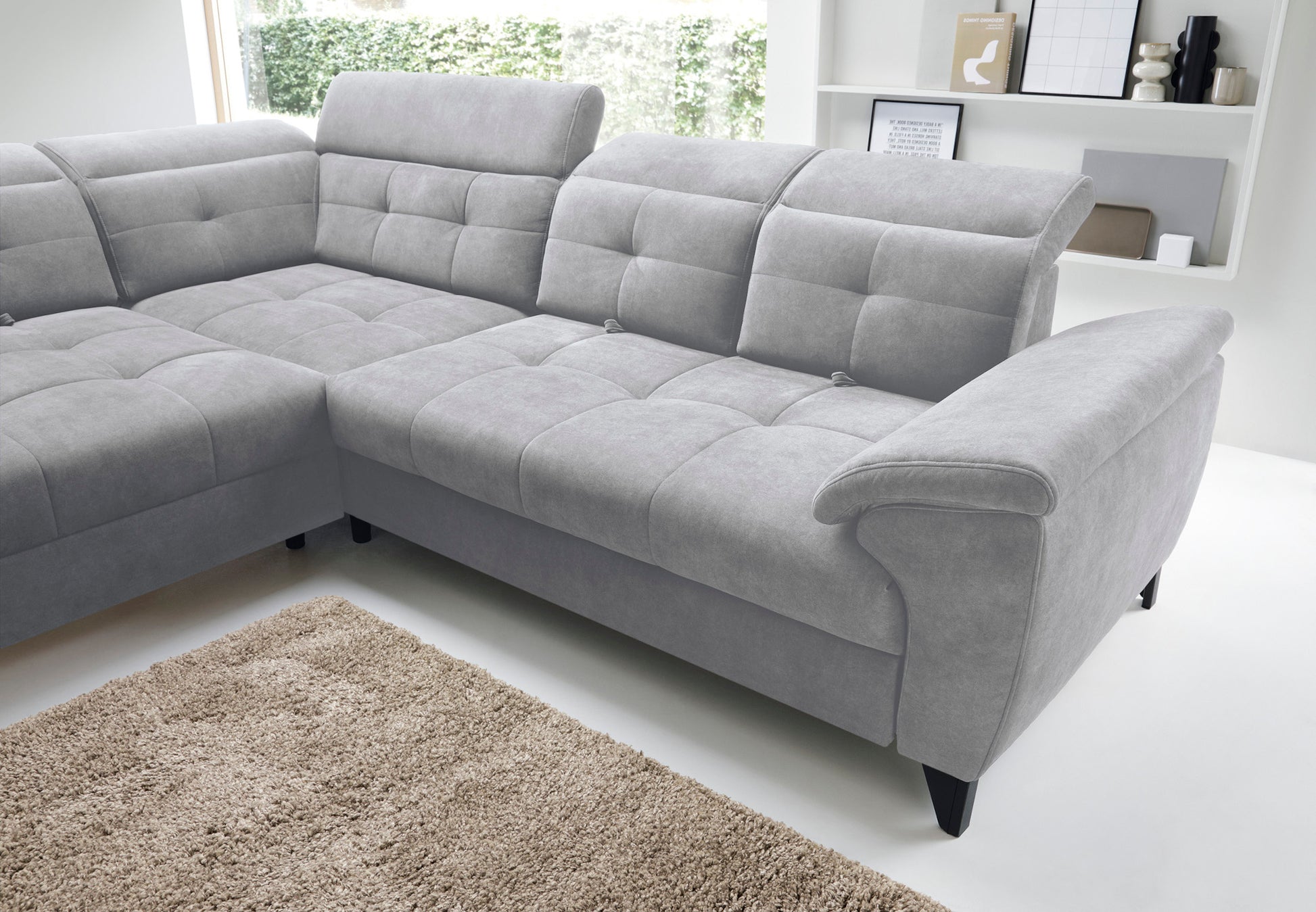 Zbliżenie na regulowane zagłówki i strukturalne pikowania oparcia narożnika Inferne Aura 04 szary w układzie lewym.