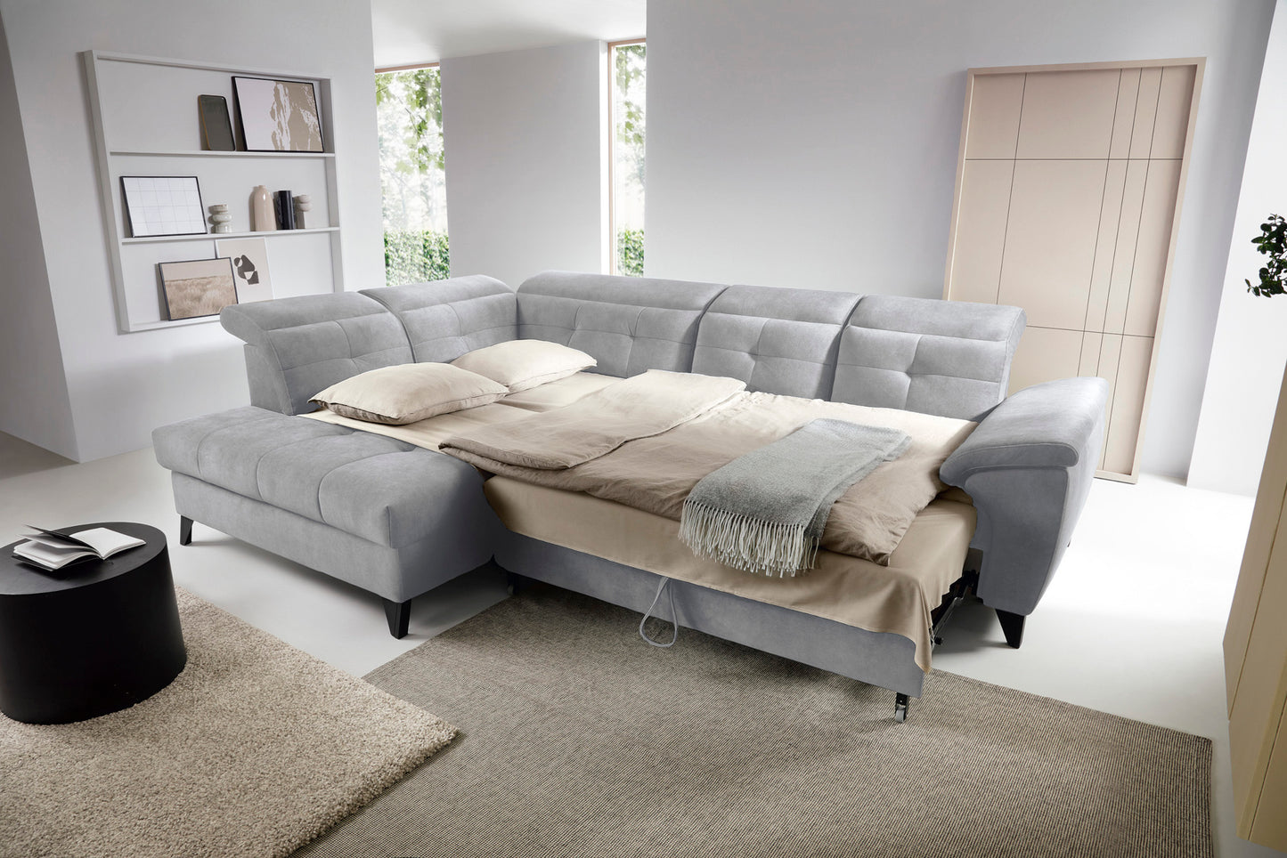 Narożnik Inferne Aura 04 szary w układzie lewym z podniesioną częścią siedziska odsłaniającą pojemnik na pościel.