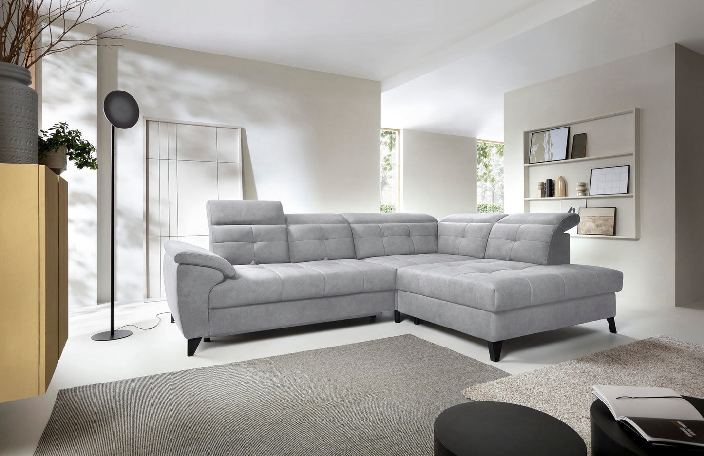 Narożnik Inferne Aura 04 szary w układzie prawym ustawiony w jasnym salonie obok stojącej lampy i dywanu.