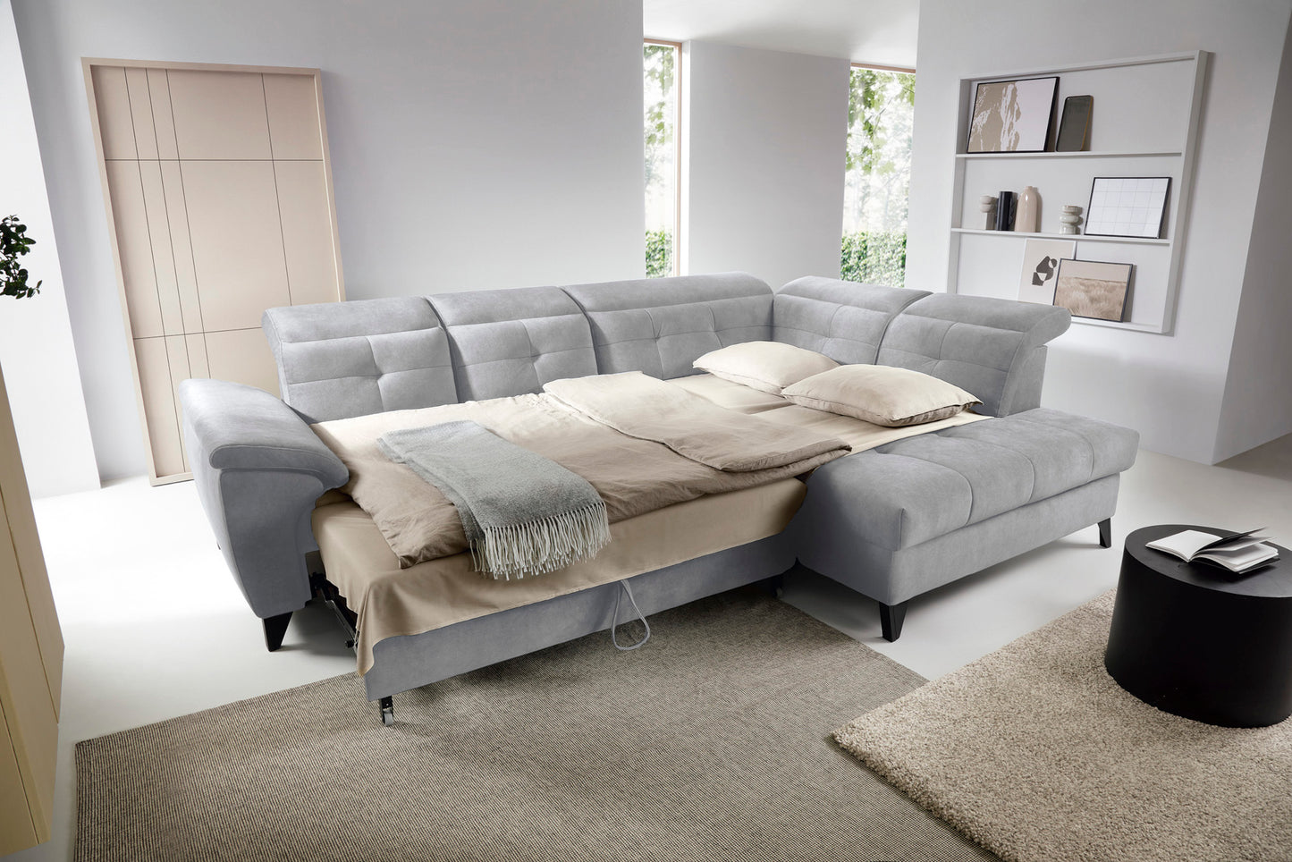 Narożnik Inferne Aura 04 szary w układzie prawym z podniesioną częścią siedziska odsłaniającą pojemnik na pościel.