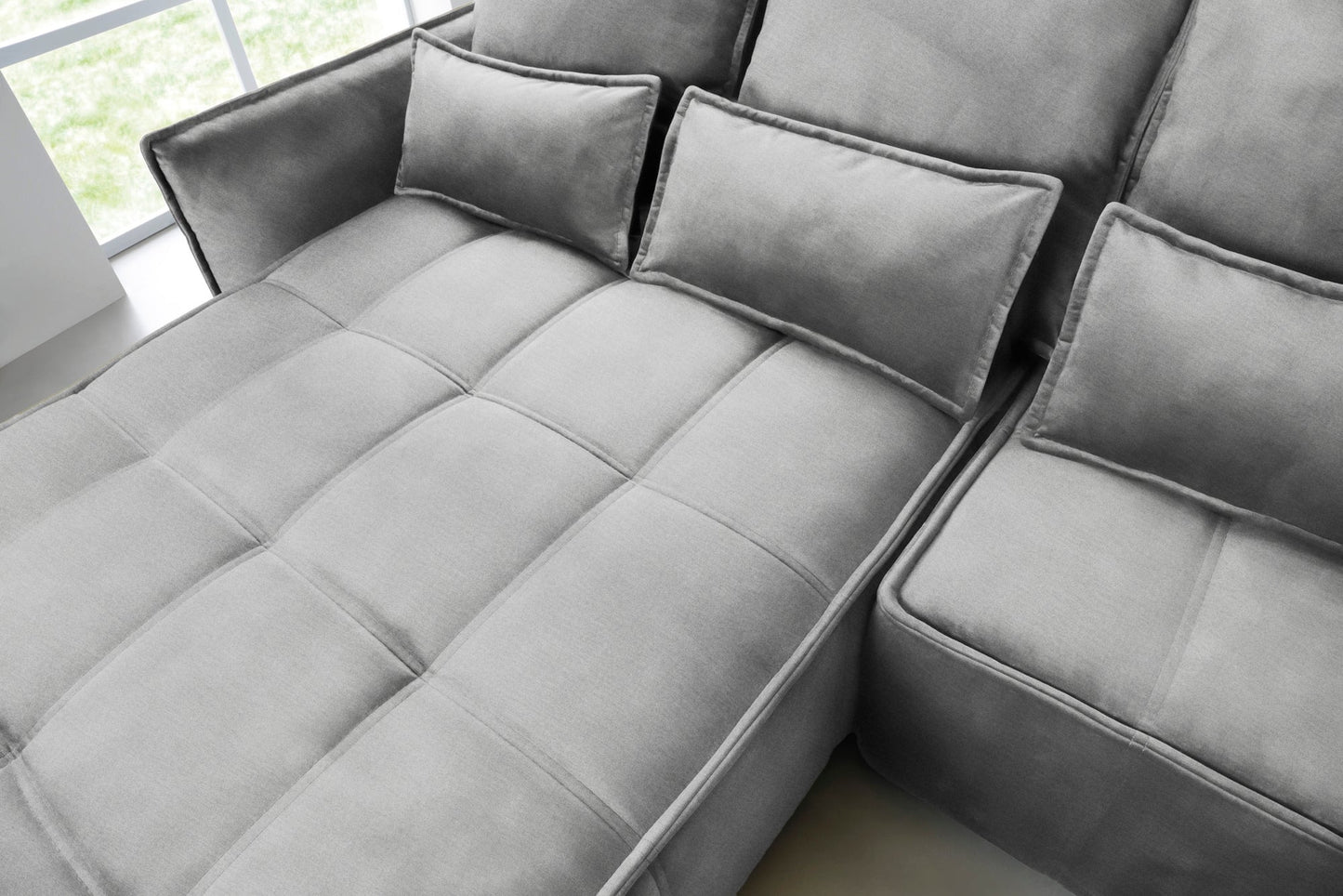 Zbliżenie na pikowane siedzisko i prostokątne poduszki narożnika Campo w układzie lewym, tkanina Nube 04 szary.