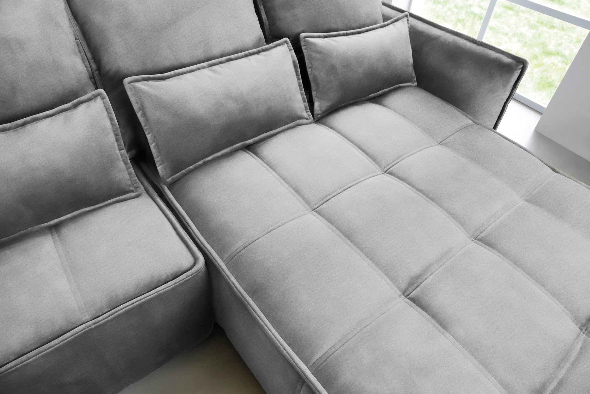 Zbliżenie na pikowane siedzisko i prostokątne poduszki narożnika Campo w układzie prawym, tkanina Nube 04 szary.