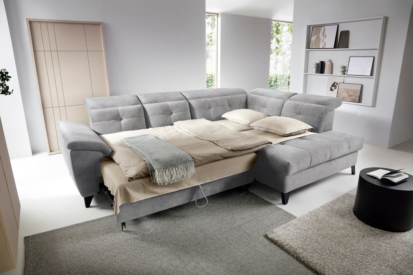 Narożnik Inferne Raquel 20 szary w układzie prawym rozłożony jako łóżko z widoczną ramą i pościelą.