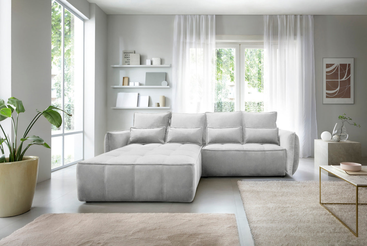 Campo układ lewy, Relax 03 szary, aranżacja wnętrza w jasnym salonie z dużymi przeszkleniami, obok stolika kawowego i donicy z zieloną rośliną, podkreślająca elegancki design narożnika.