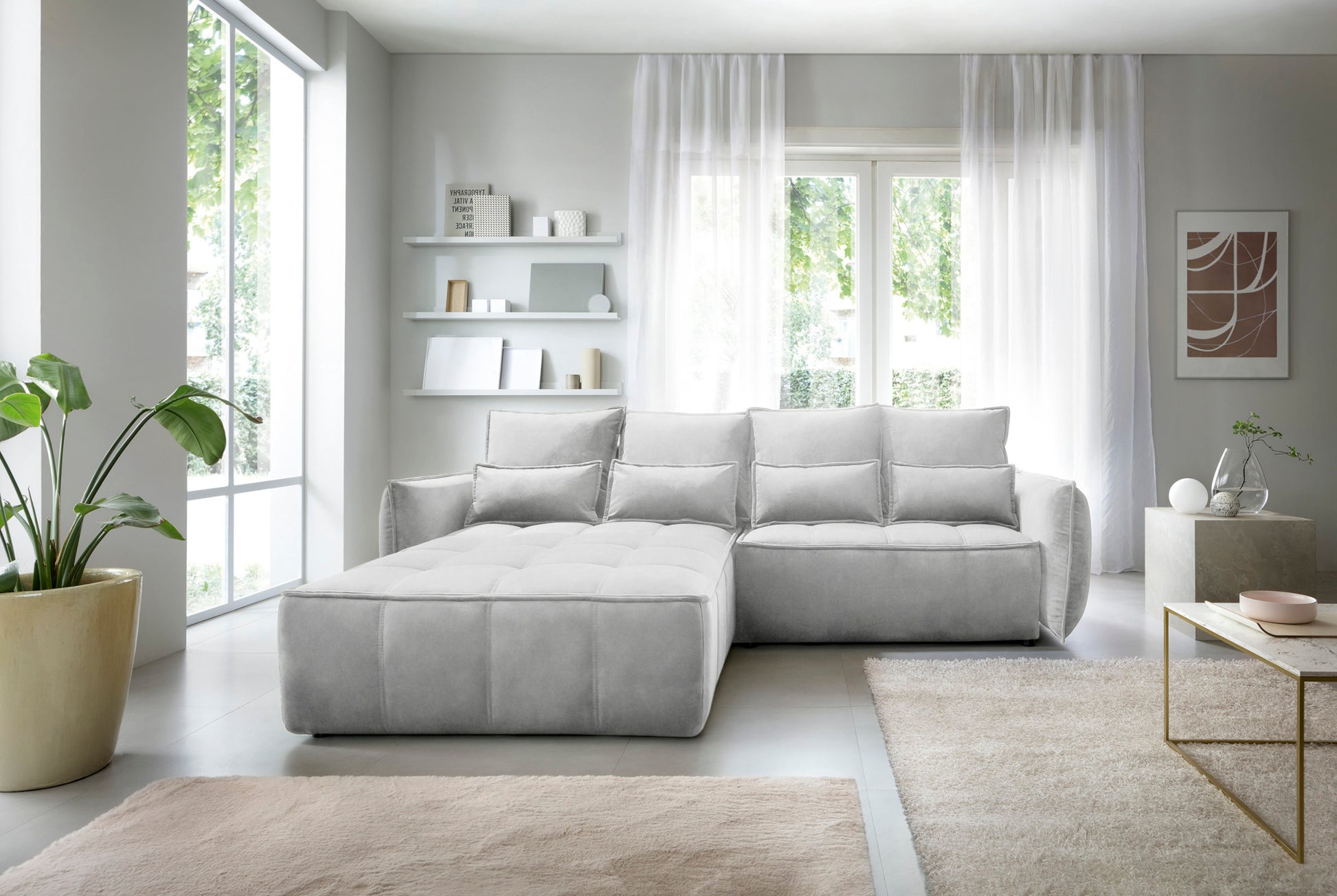 Campo układ lewy, Relax 03 szary, aranżacja wnętrza w jasnym salonie z dużymi przeszkleniami, obok stolika kawowego i donicy z zieloną rośliną, podkreślająca elegancki design narożnika.