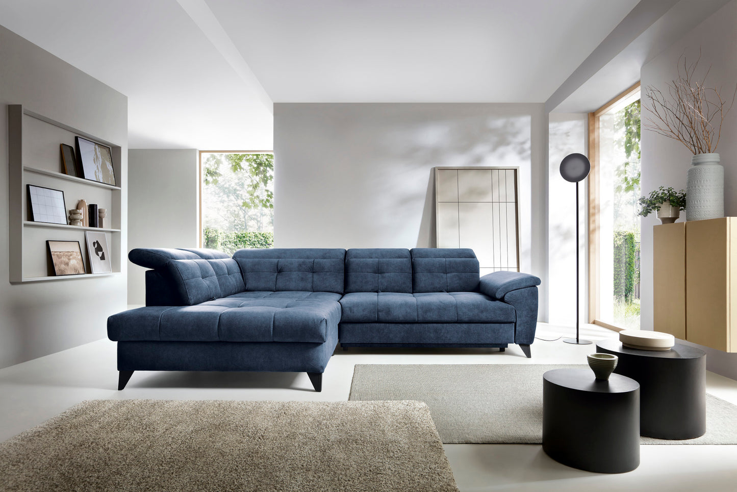 Narożnik Inferne Aura 40 zgaszony niebieski w układzie lewym ustawiony w nowoczesnym salonie obok stolików kawowych i lampy stojącej.