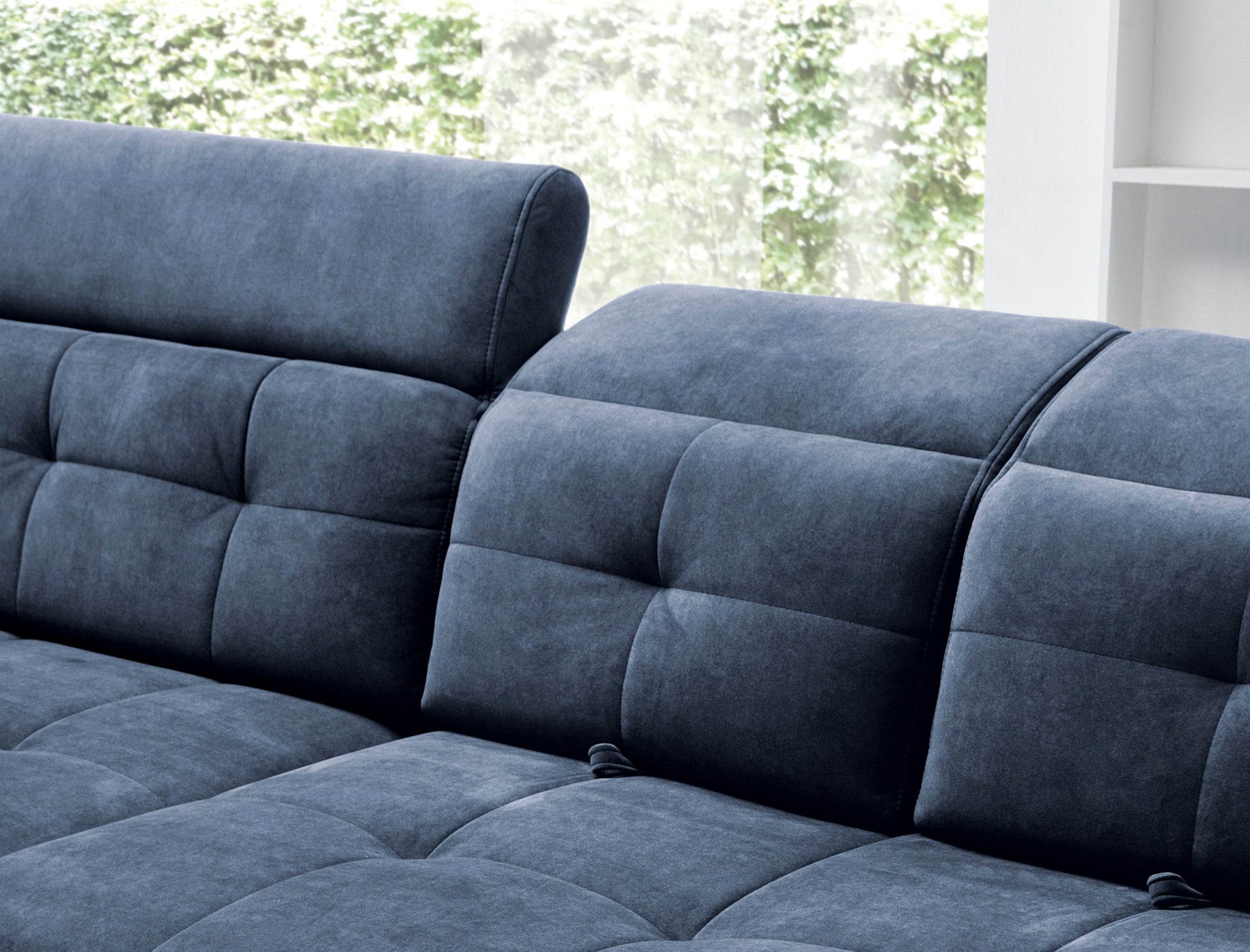 Zbliżenie na pikowany panel siedziska i zaokrąglony podłokietnik narożnika Inferne Aura 40 zgaszony niebieski.